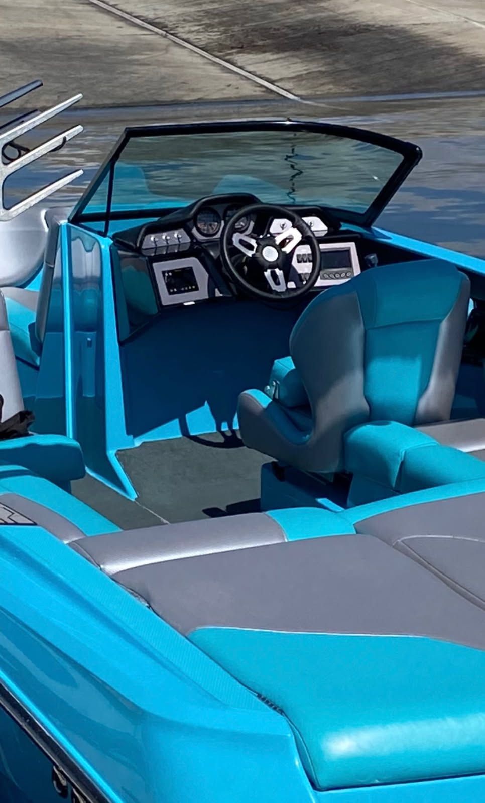 Interior of a blue 2021 MasterCraft NXT22 boat by the water.