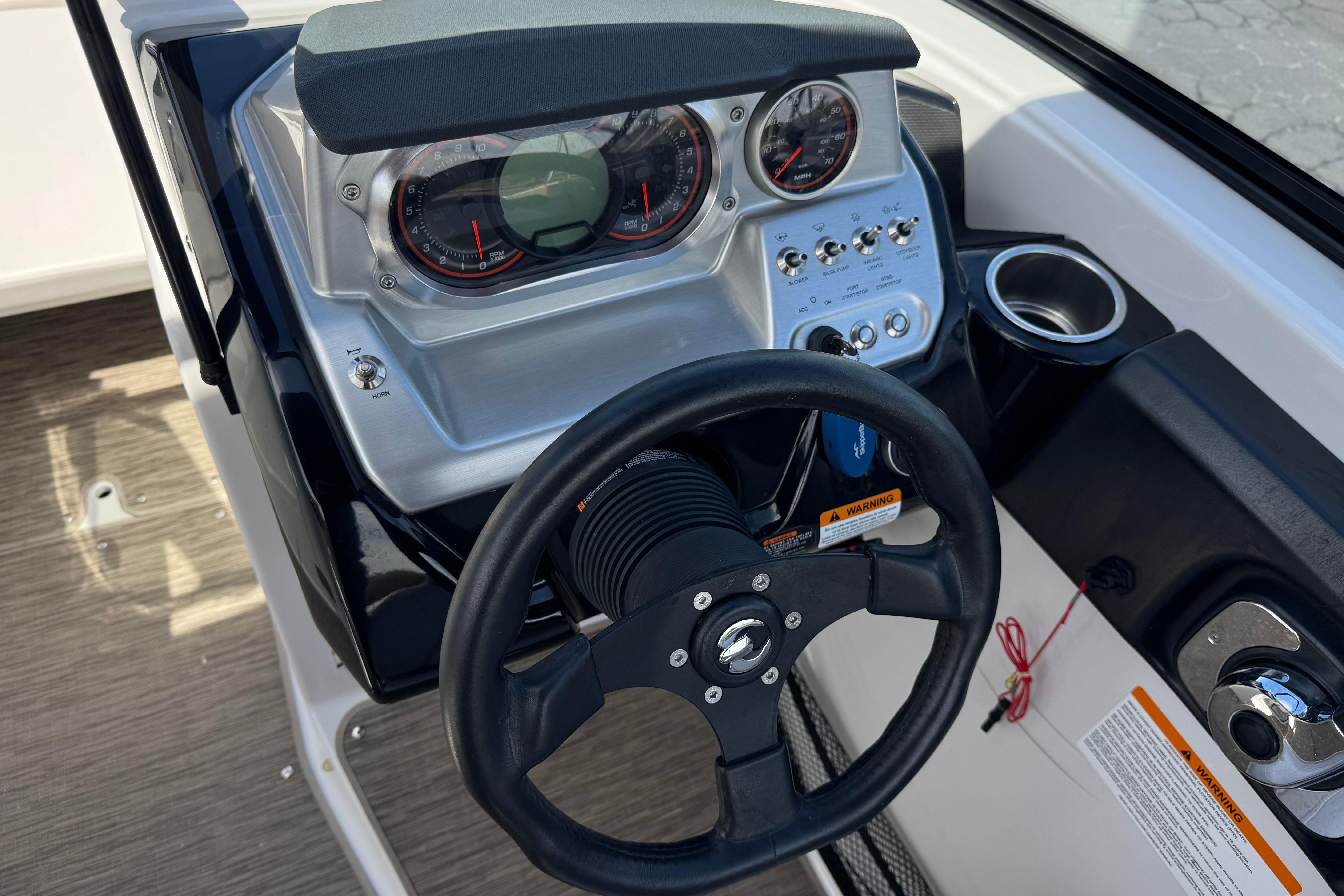 Dashboard of a 2017 Scarab 255 H.O. Platinum boat with steering wheel and gauges.