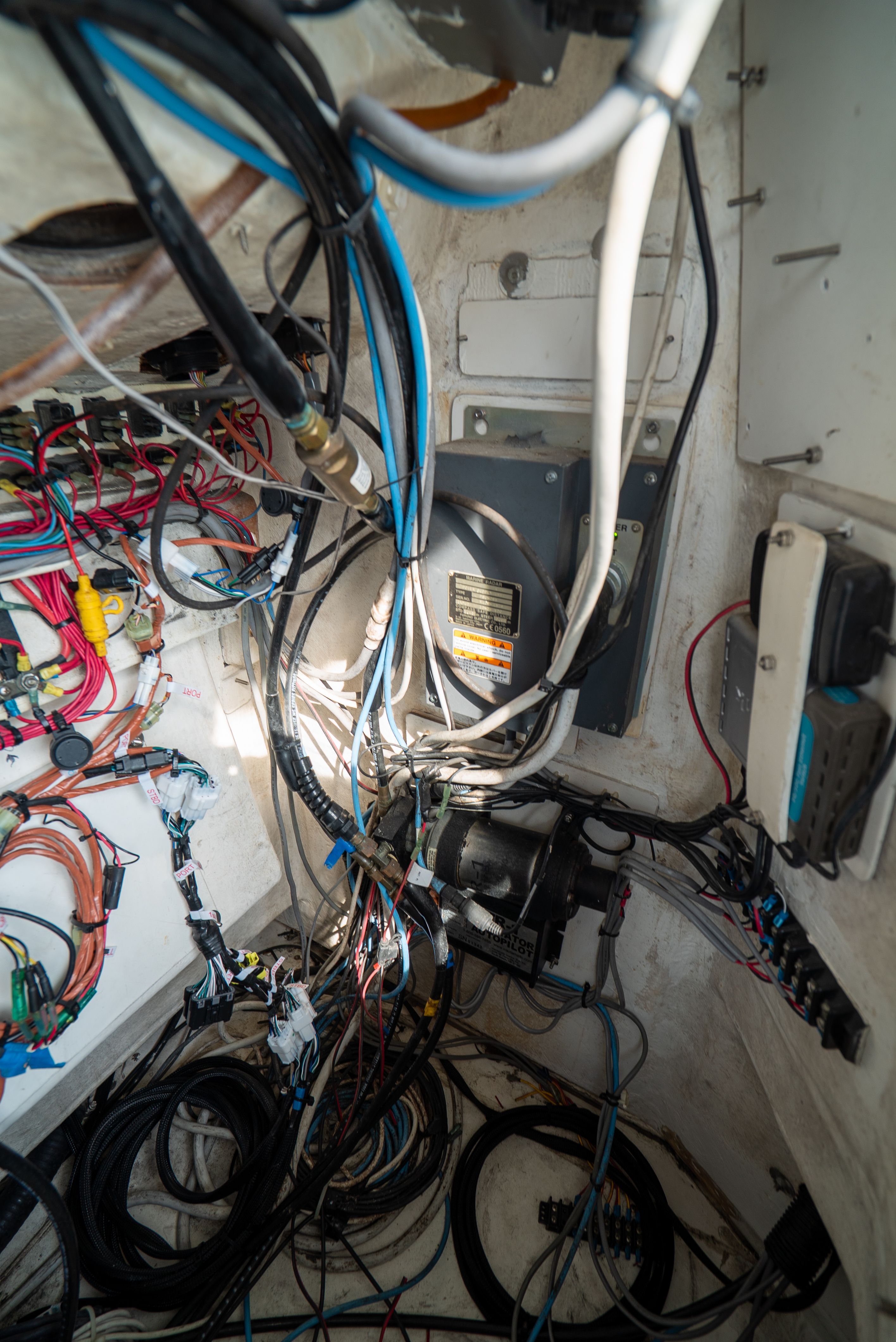 A complex wiring harness and electrical components inside a boat.