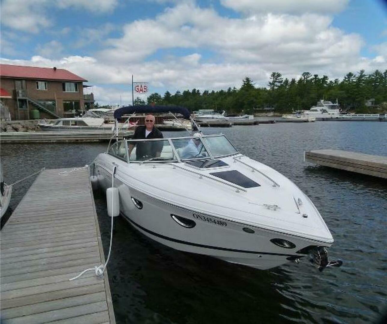 2012 Cobalt 273 boat docked at marina under cloudy sky.