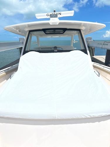 2019 Pursuit S 408 Sport boat with a sunbed, under a clear blue sky.