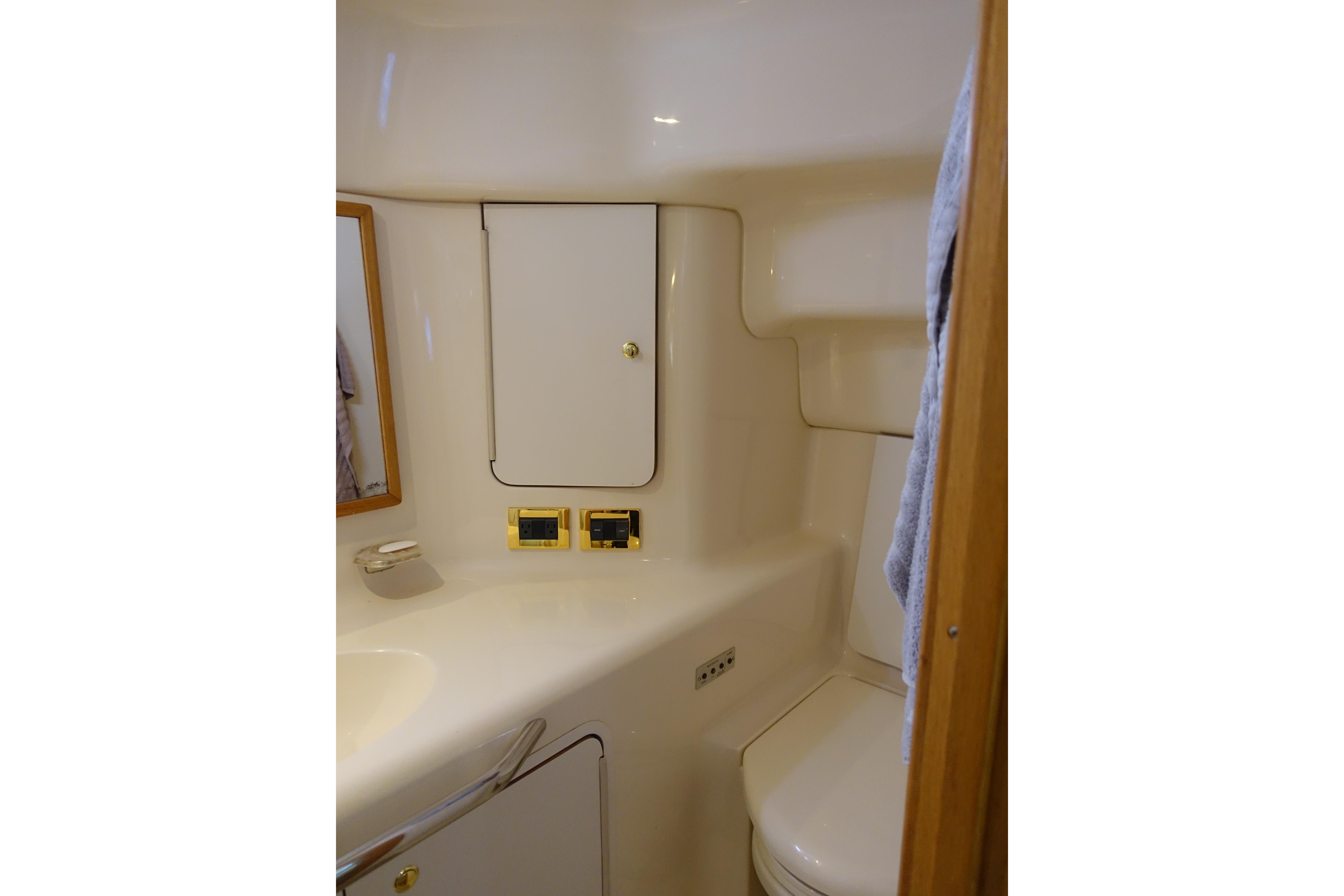 1999 Sea Ray 420 Aft Cabin bathroom with compact design and storage cabinets.