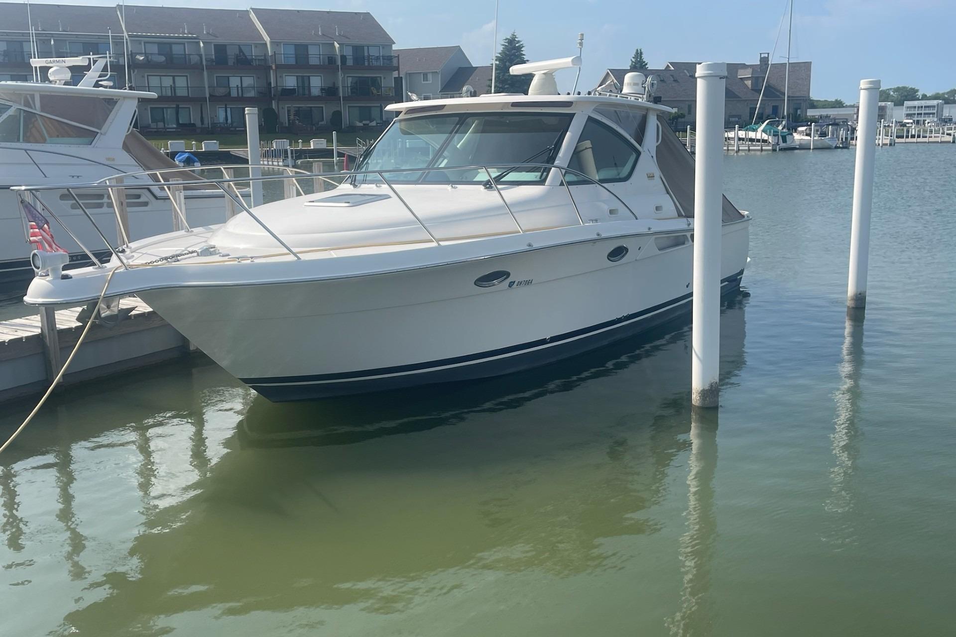 2013 Tiara Yachts 3100 Open docked in a marina, calm water, residential backdrop.