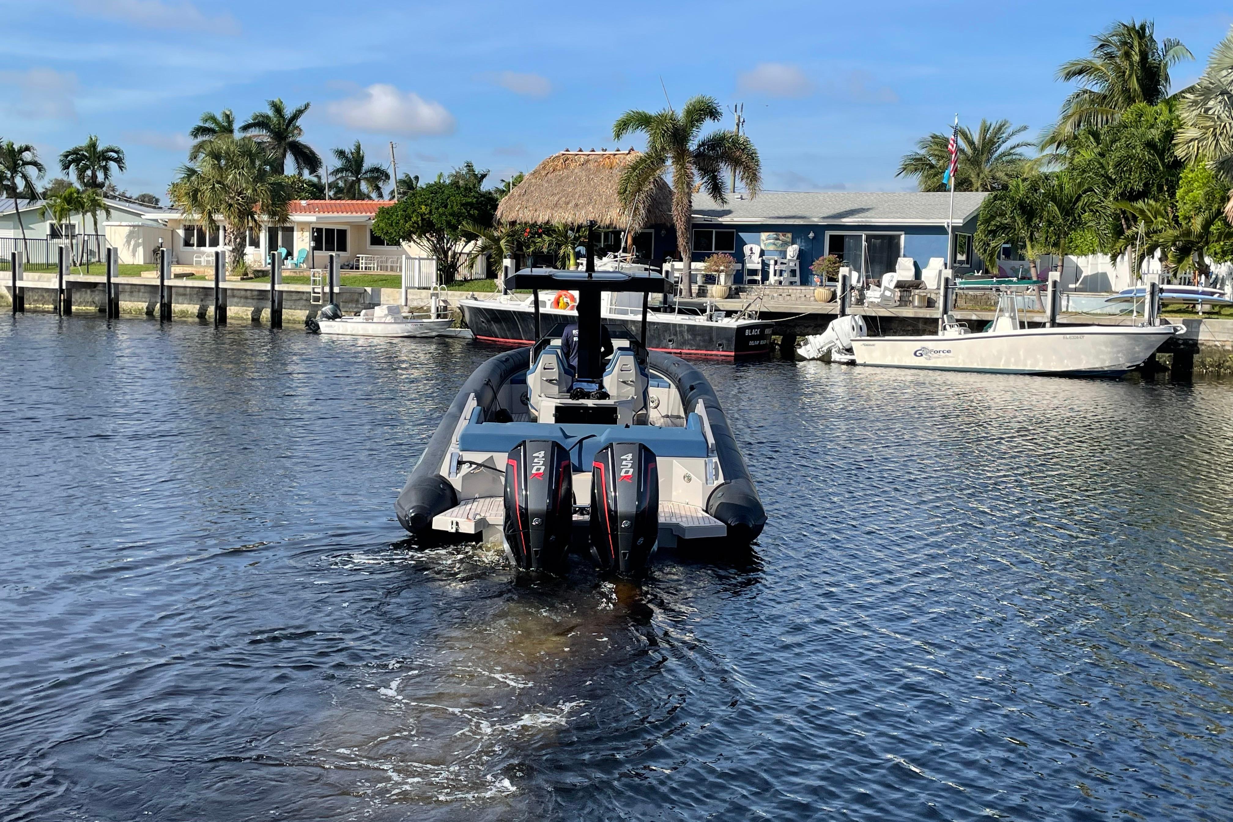 2023 Skipper-BSK BSK 38 boat on a sunny waterfront with palm trees.