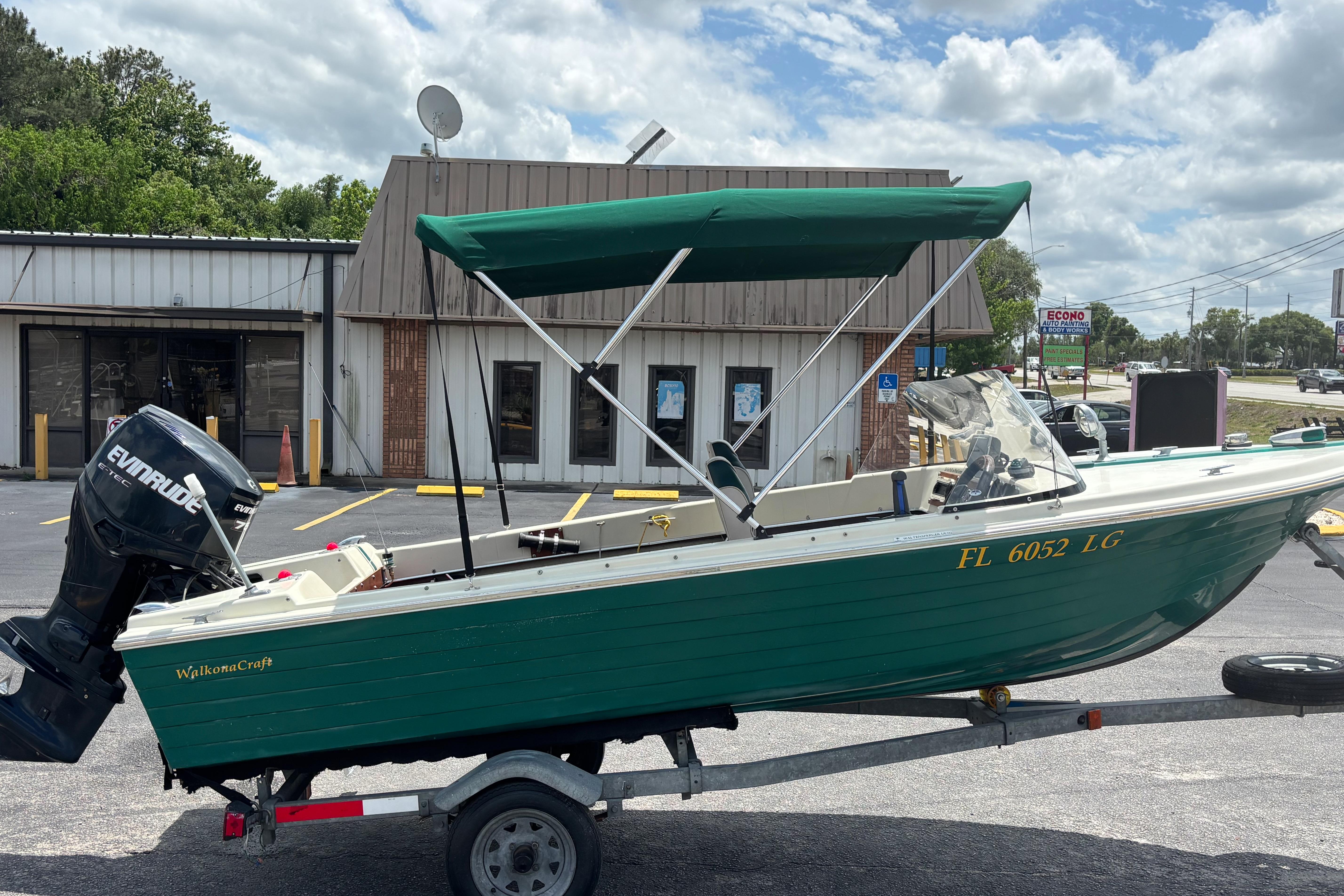 1966 Mohawk 15 boat with green hull and Evinrude motor on trailer.