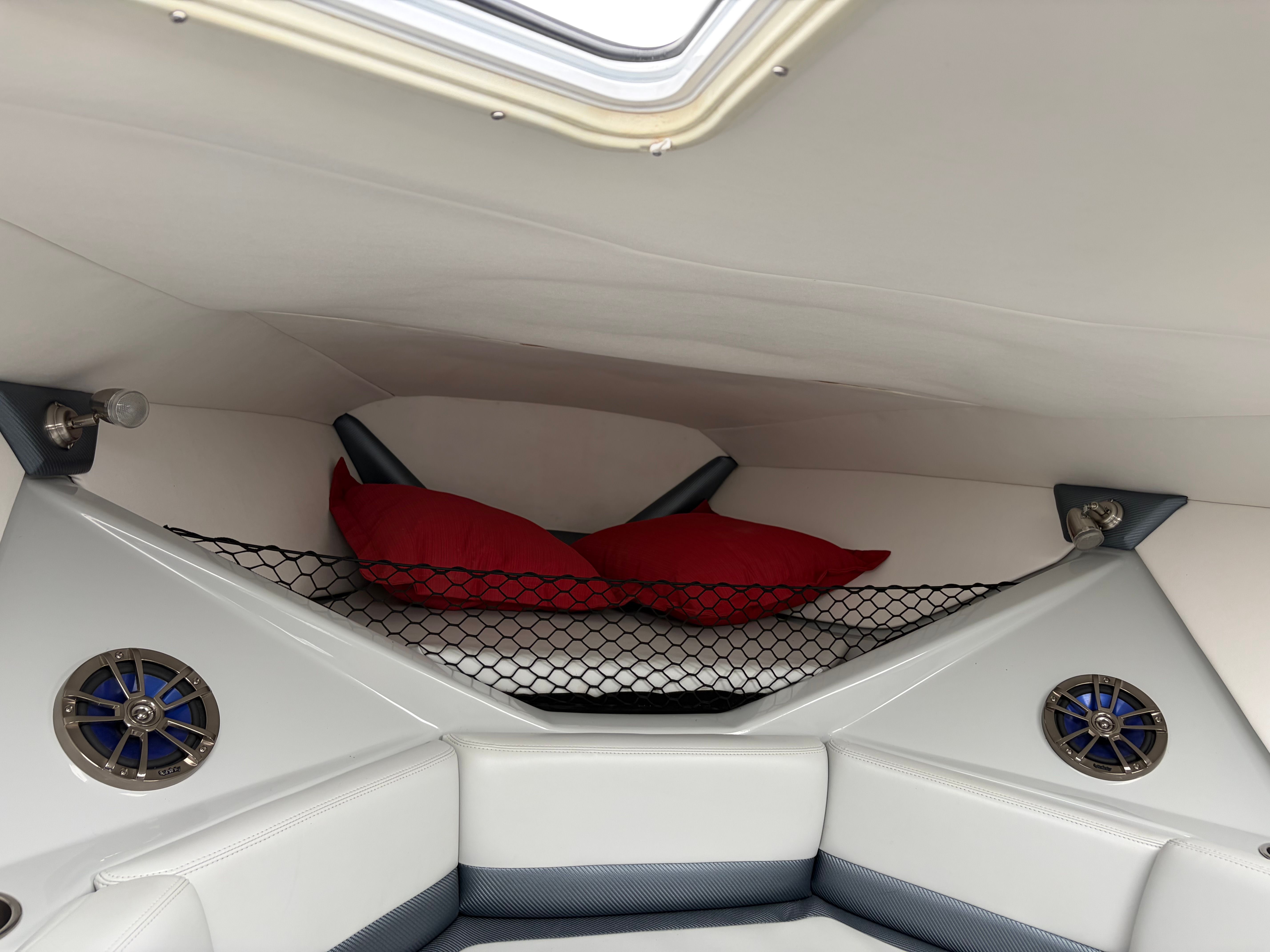 Interior of a 2007 Baja 30 Outlaw boat with red pillows.