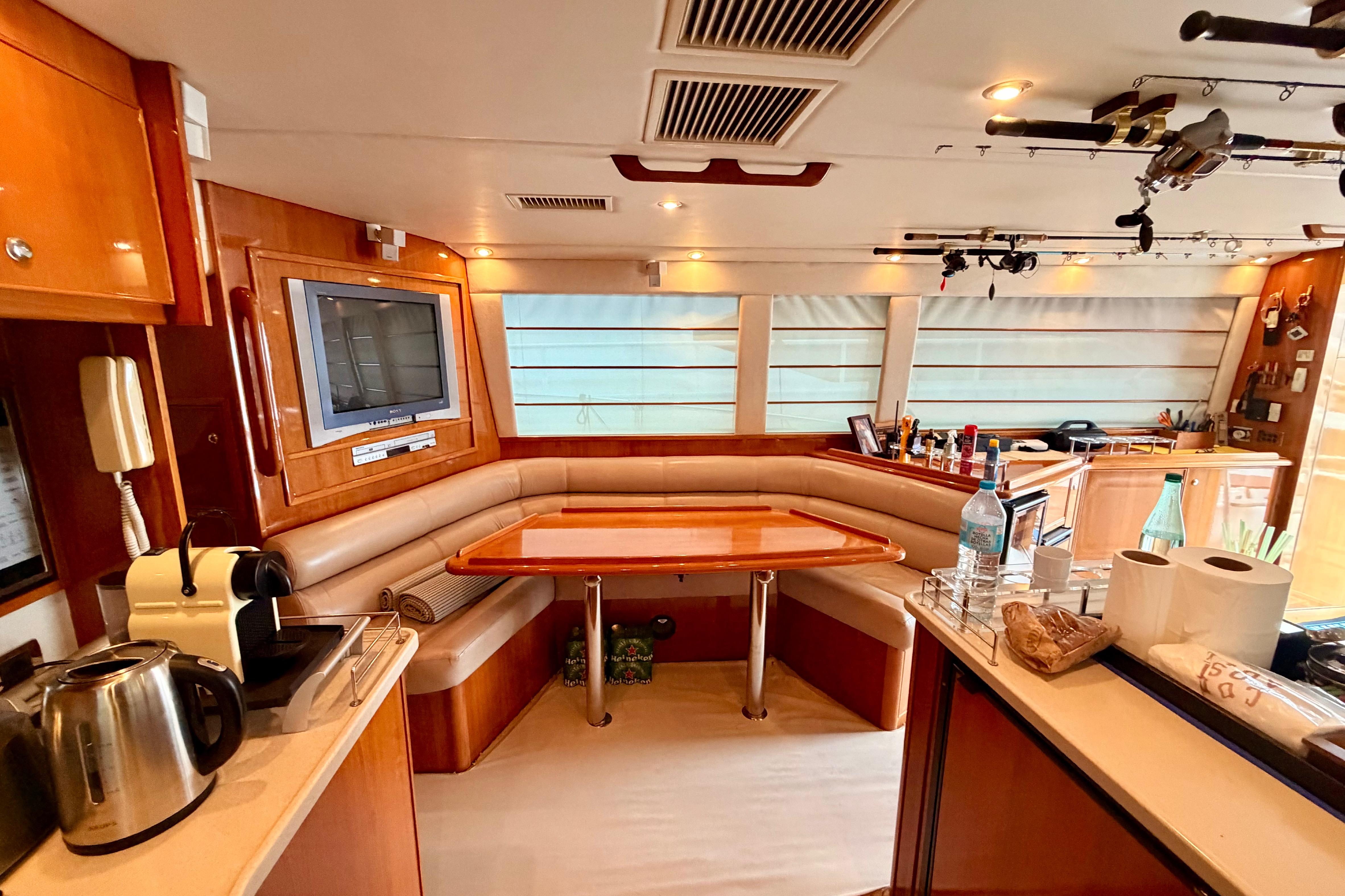 Luxurious interior of a 2004 Riviera 60 Flybridge yacht with dining area and modern amenities.