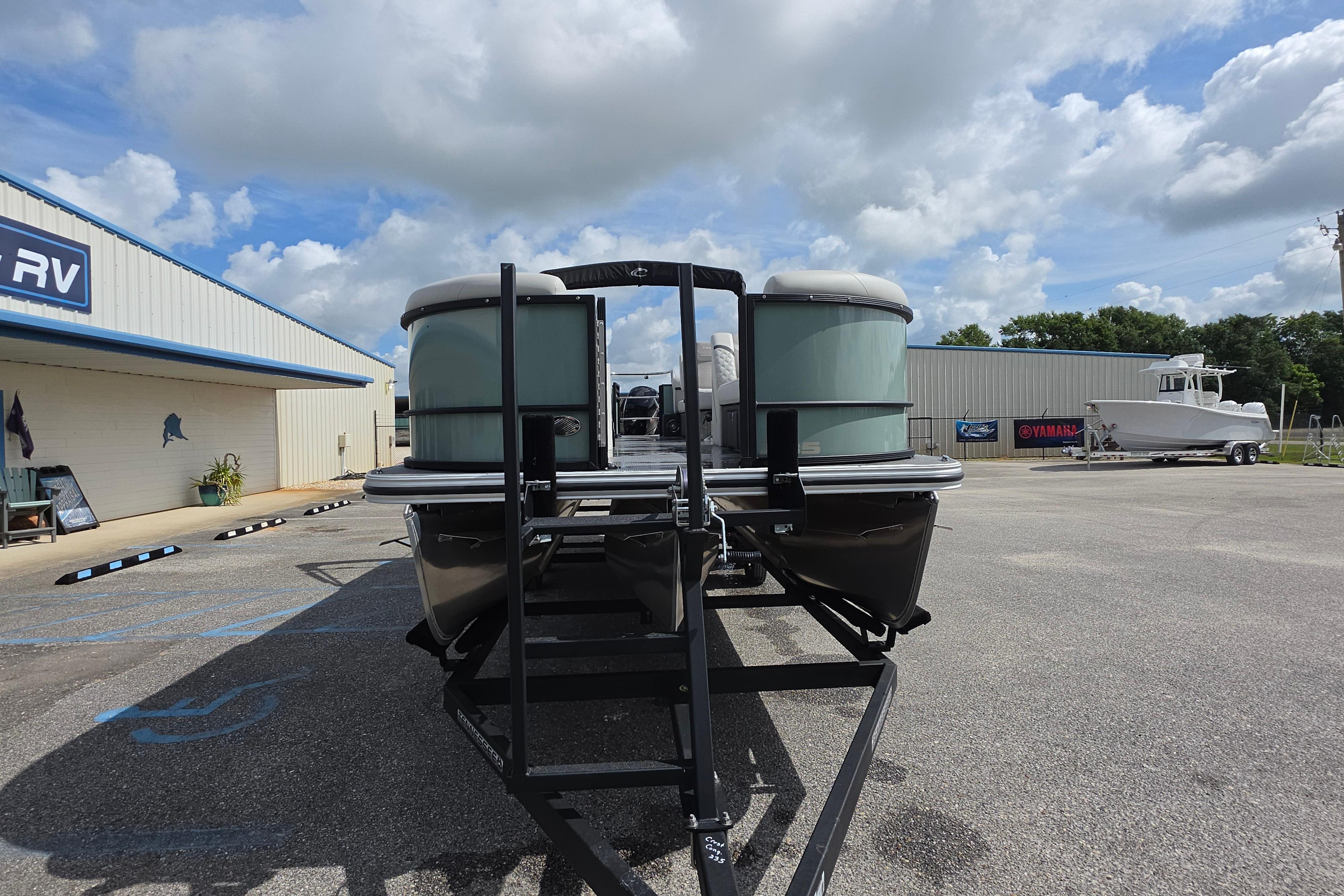 2026 Crest 235 Conquest SLC pontoon boat on trailer at dealership under cloudy sky.