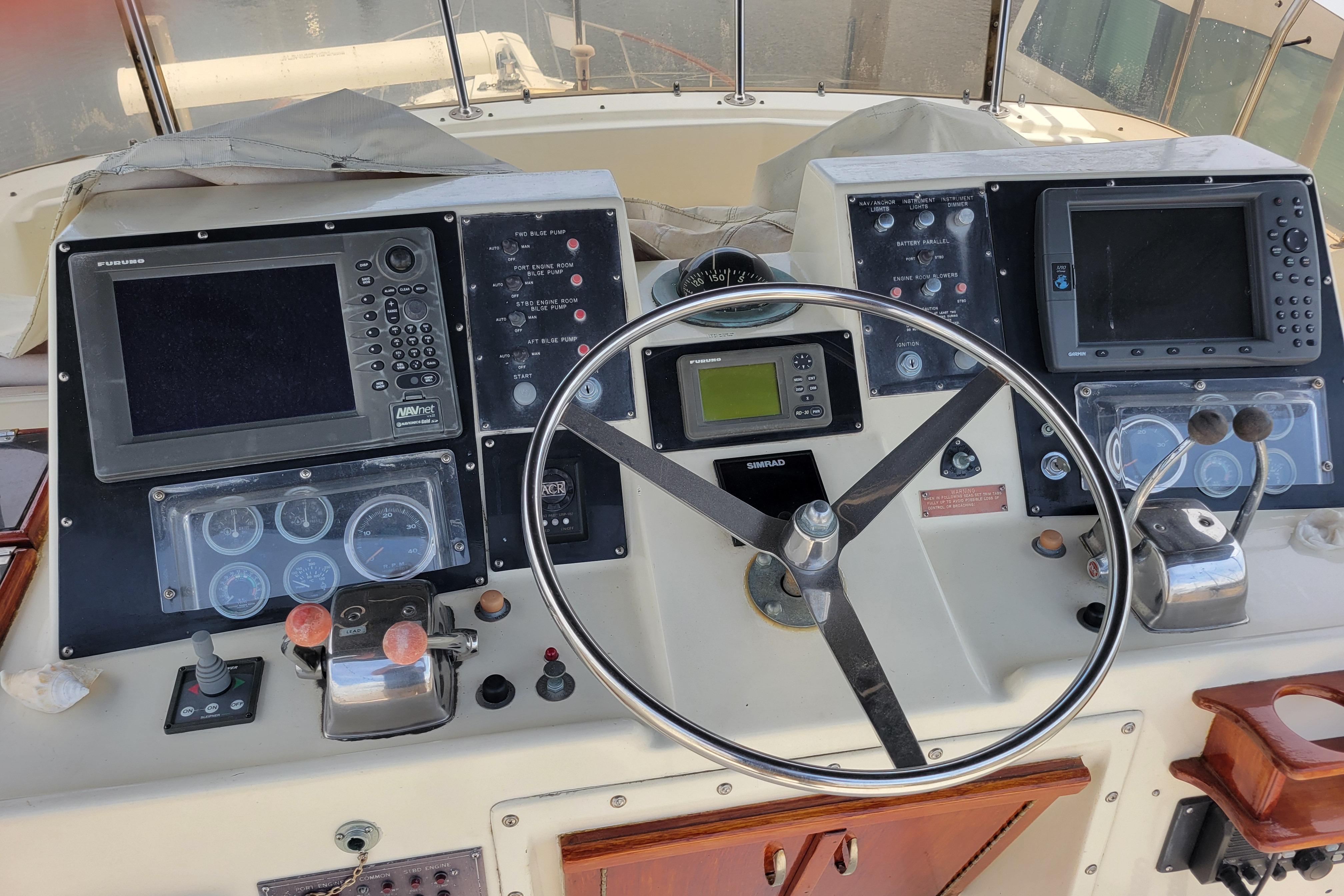 Helm of 1980 Hatteras 53 Yacht Fisherman with navigation equipment and steering wheel.