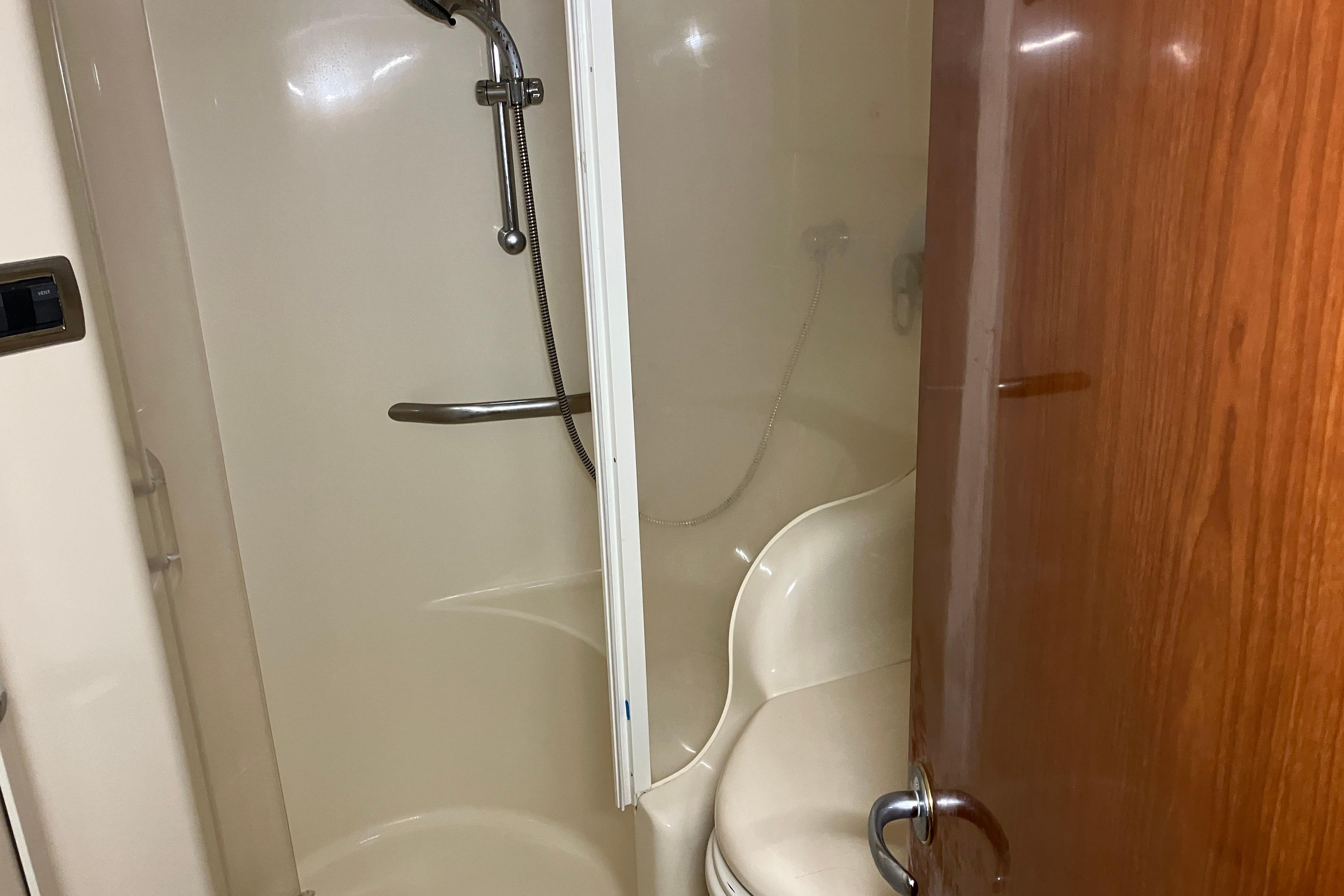 Shower area inside 2002 Sea Ray 410 Sundancer yacht, featuring a compact design.