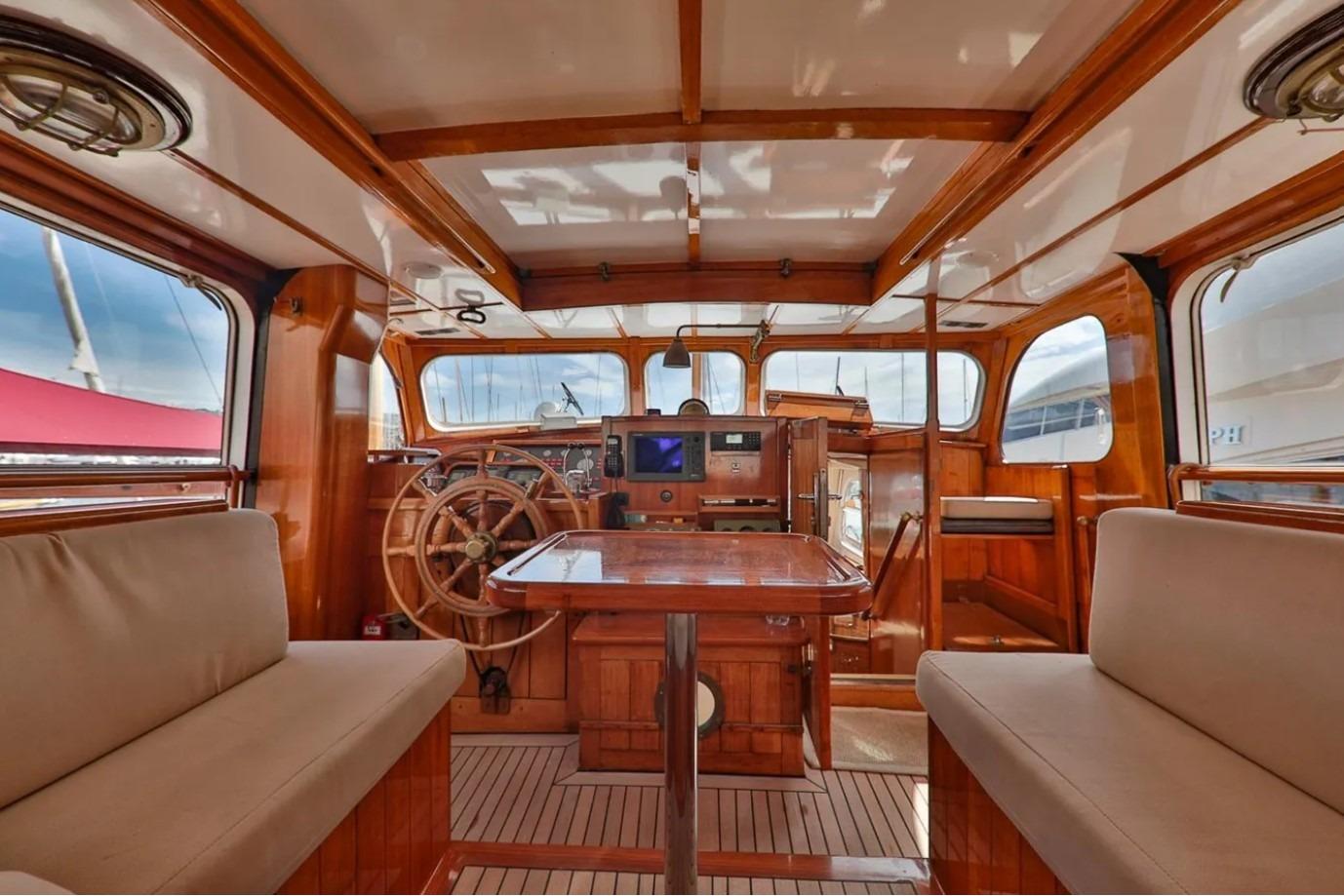 Luxurious interior of 1958 Feadship Custom 25m yacht with wooden finishes and helm station.