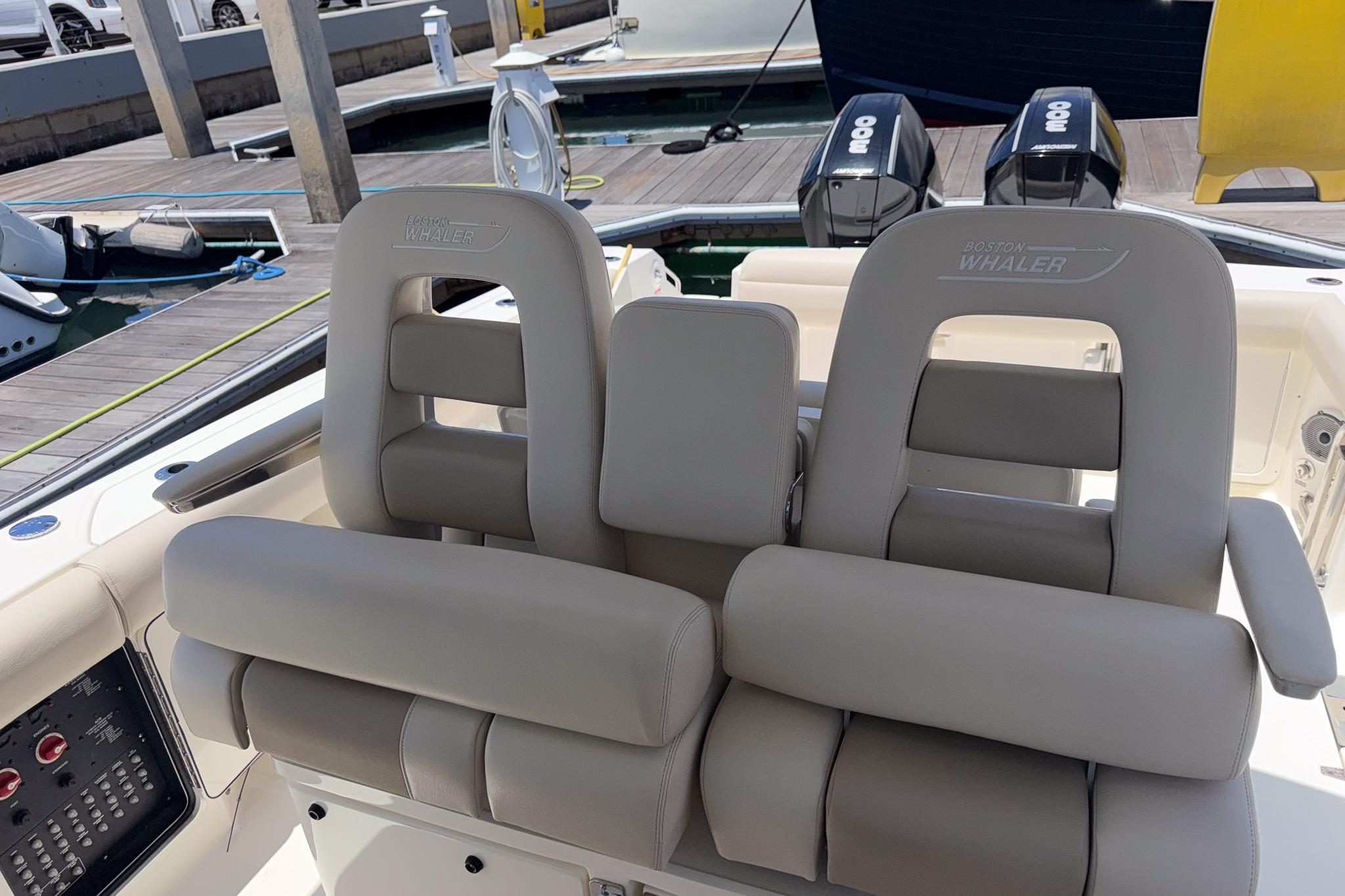 2021 Boston Whaler 330 Outrage boat seats with dual outboard motors at dock.