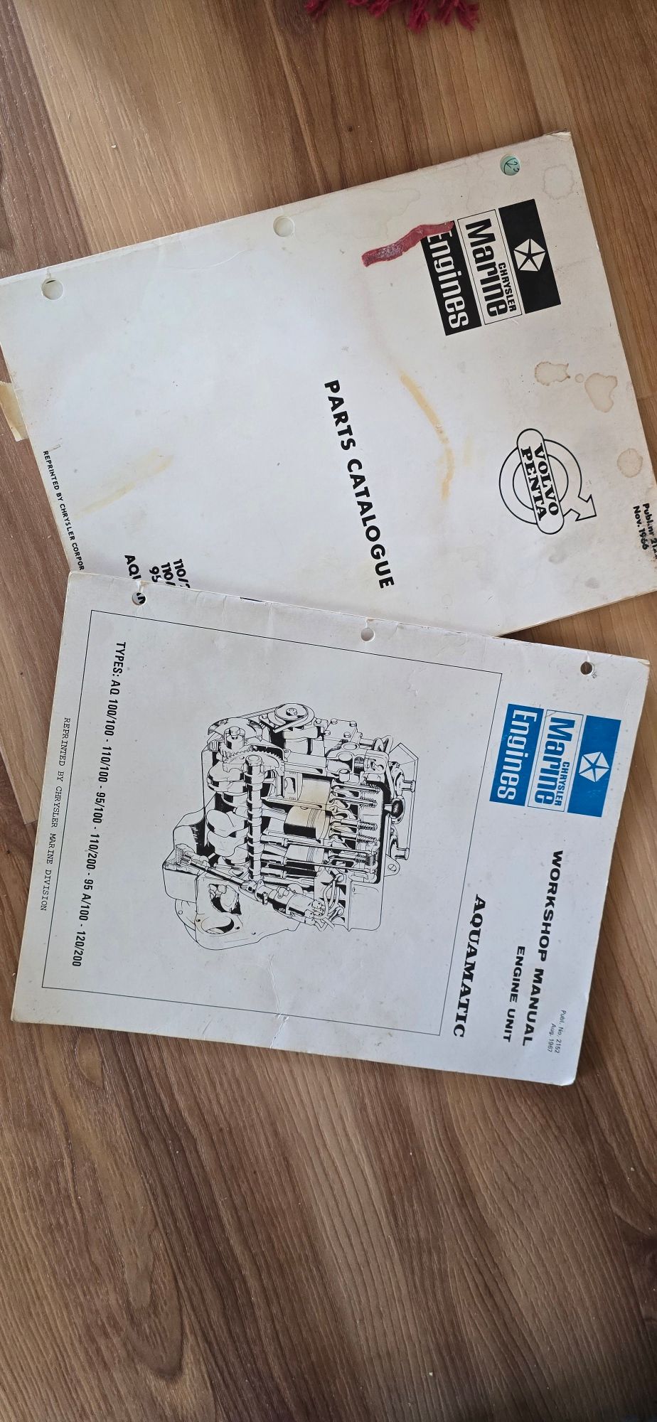1969 Chrysler Aquamatic manuals on wooden floor, featuring parts catalogue and workshop instructions.