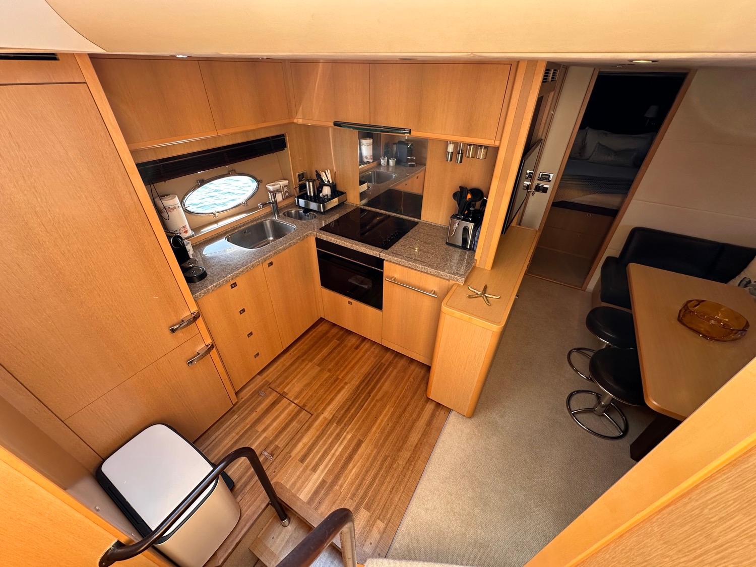Luxurious 2009 Princess V62 yacht kitchen with modern amenities and elegant wood finish.