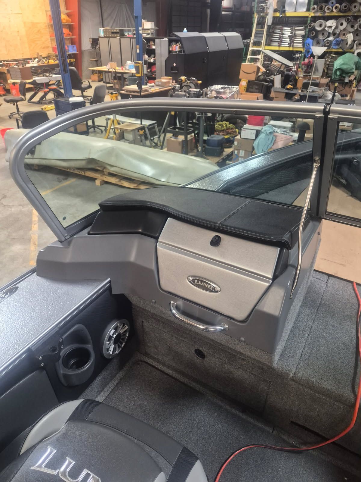 The image shows the cockpit of a 2017 Lund Pro-V 2075 boat in a workshop.