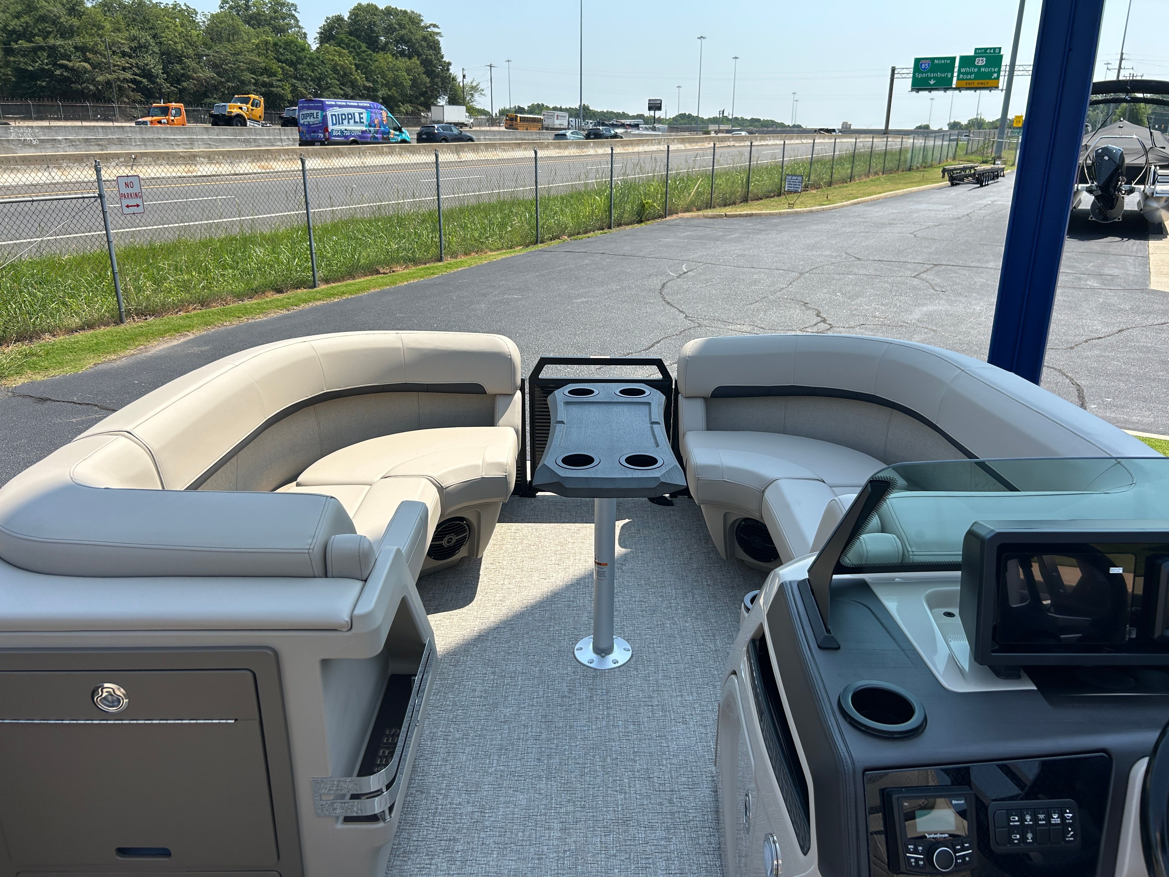 The image shows the interior of a Bennington 22 MFB boat with beige seating and a table.