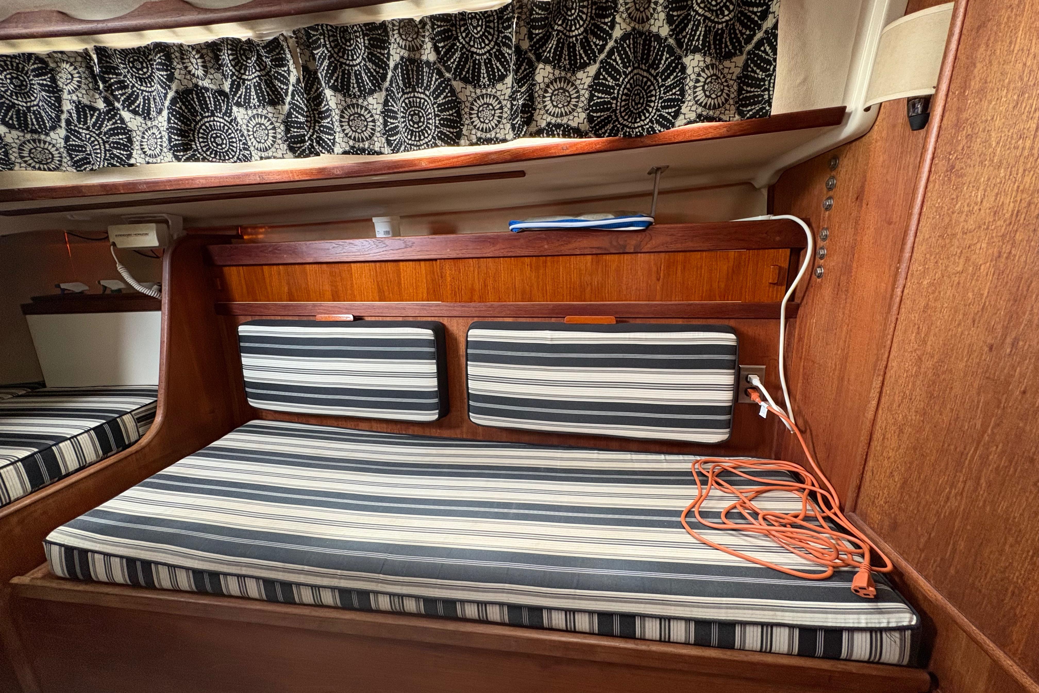 Interior of 1981 Sabre 31 sailboat with striped cushions and wooden paneling.