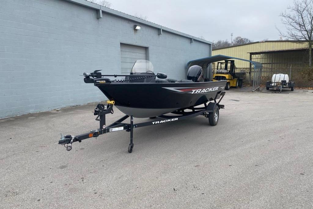 2026 Tracker Pro Guide V-16 SC boat on trailer in industrial setting.