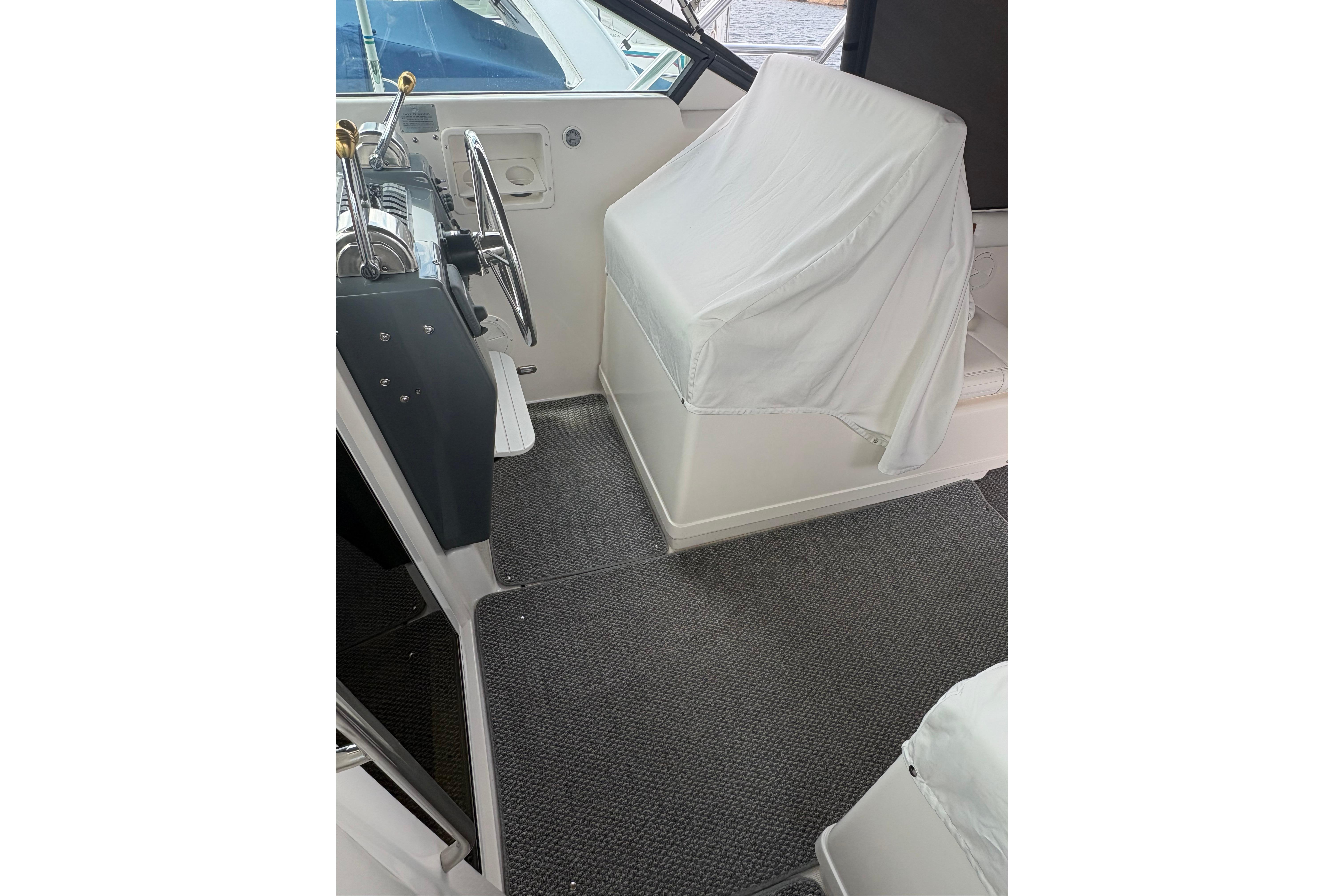 1999 Tiara Yachts 3100 Open helm area with covered seating and steering wheel.