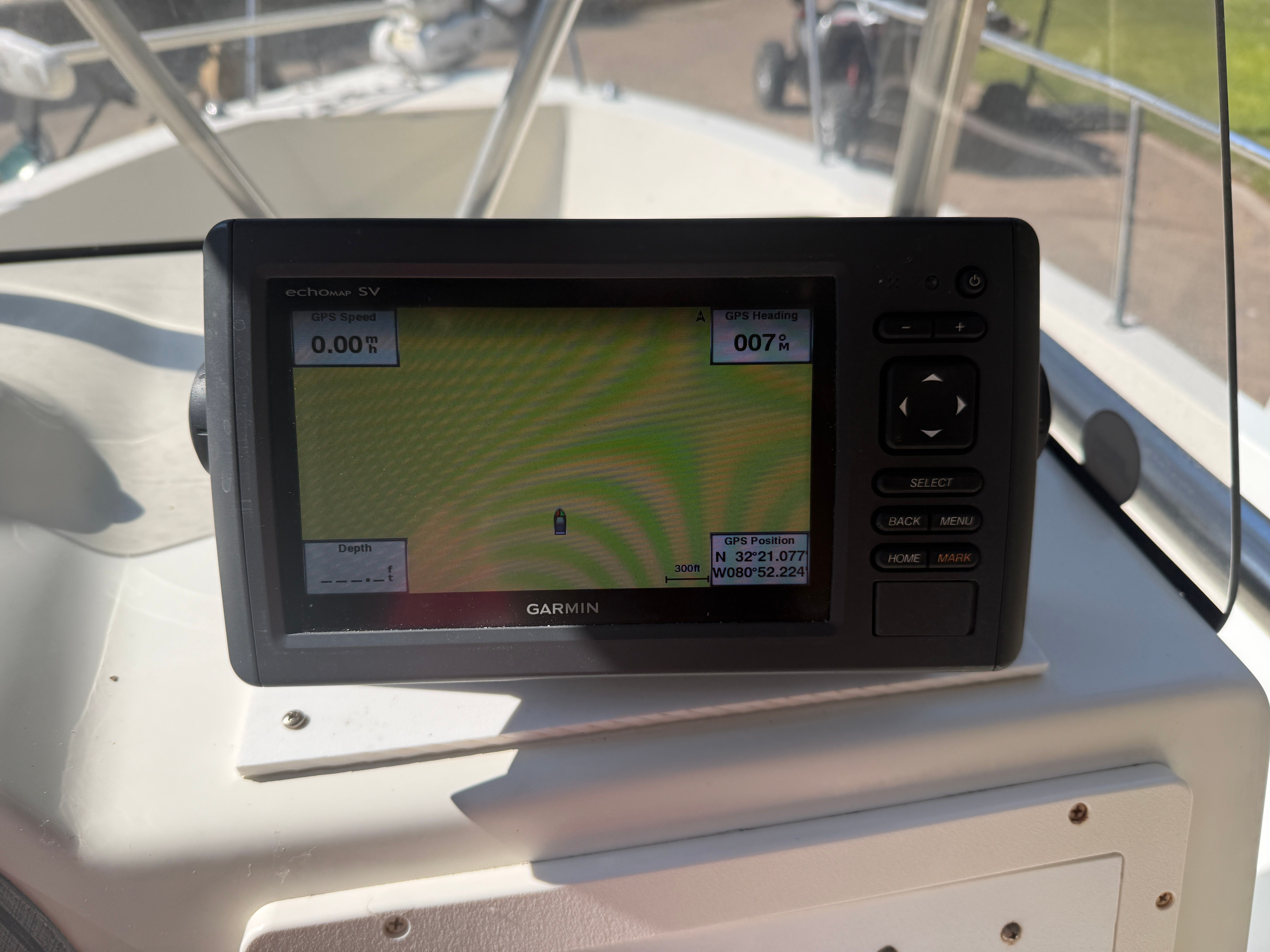 A Garmin GPS device on a boat displays speed and position.