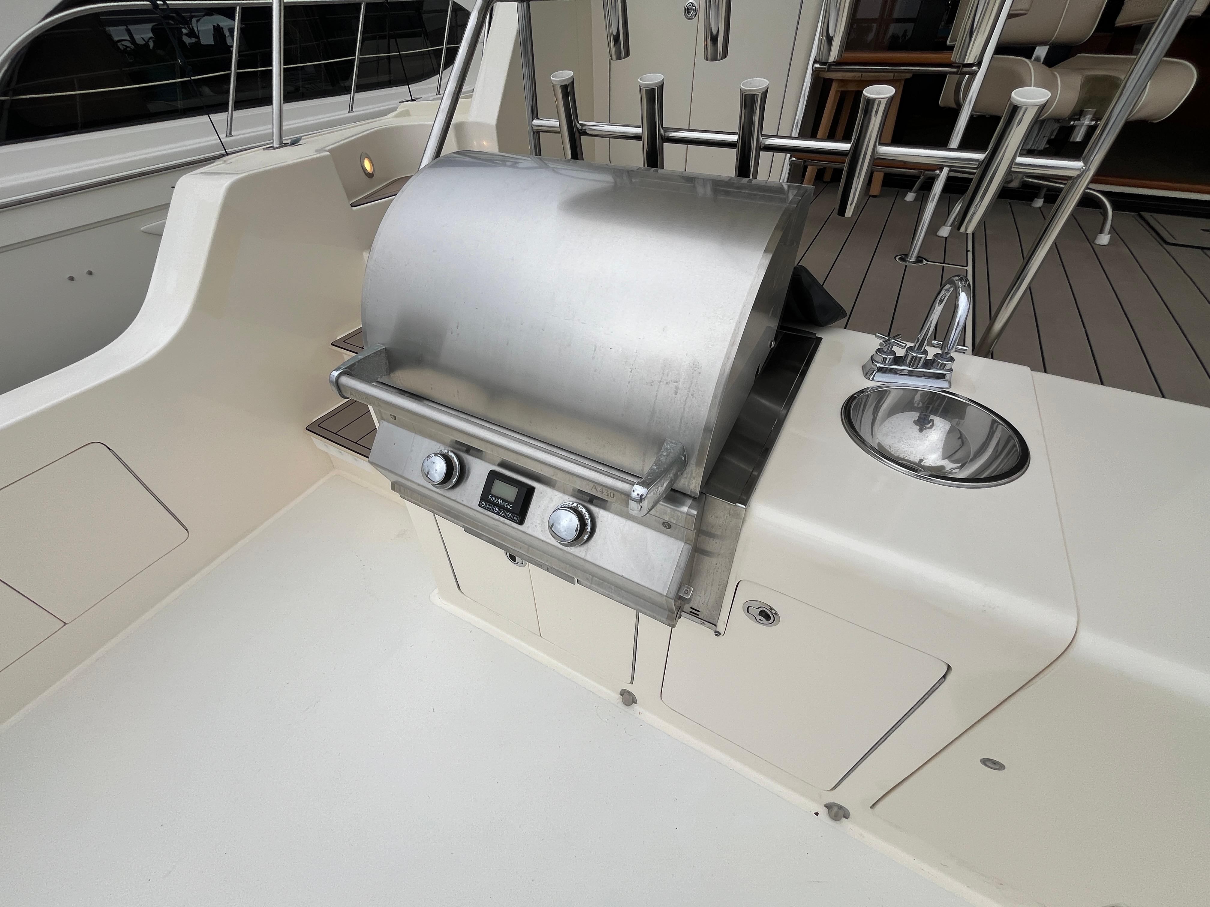 Outdoor grill and sink on 1999 Mikelson Long-Range Luxury Sportfisher yacht deck.