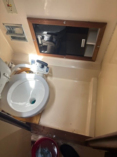 A small boat bathroom with a toilet and mirror.