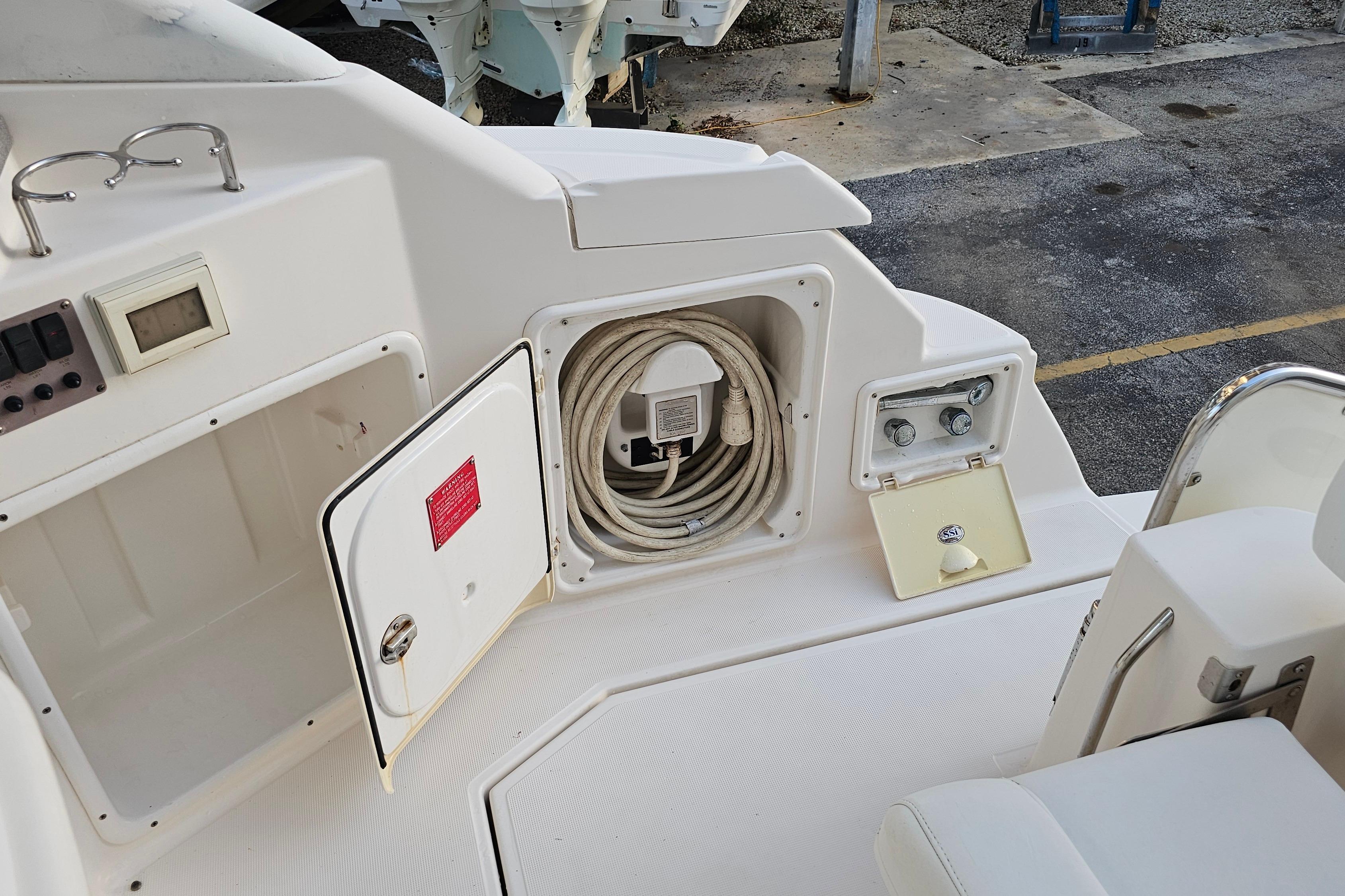 2005 Regal 3060 Window Express boat deck with storage compartments and coiled hose.