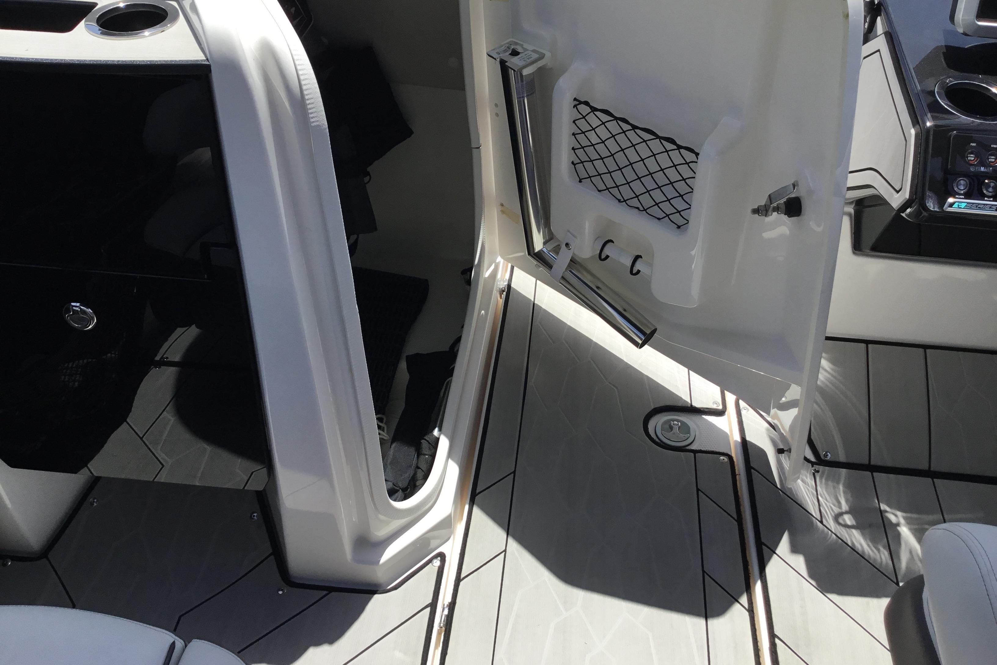 Interior view of 2023 Yamaha Boats 252XE, featuring open storage compartment and sleek flooring.