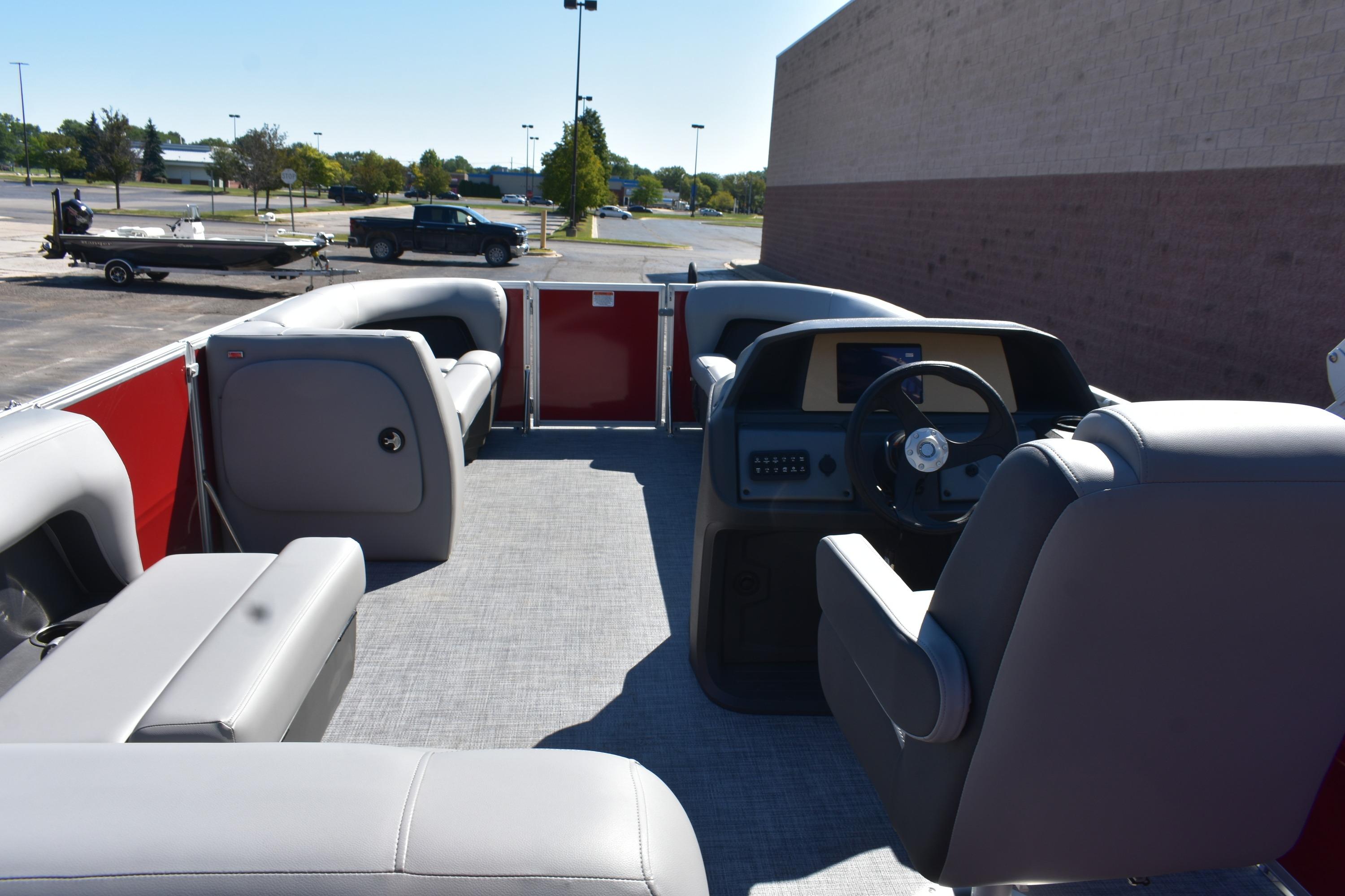 2026 Sun Tracker Party Barge 18 DLX interior with gray seating and steering console.