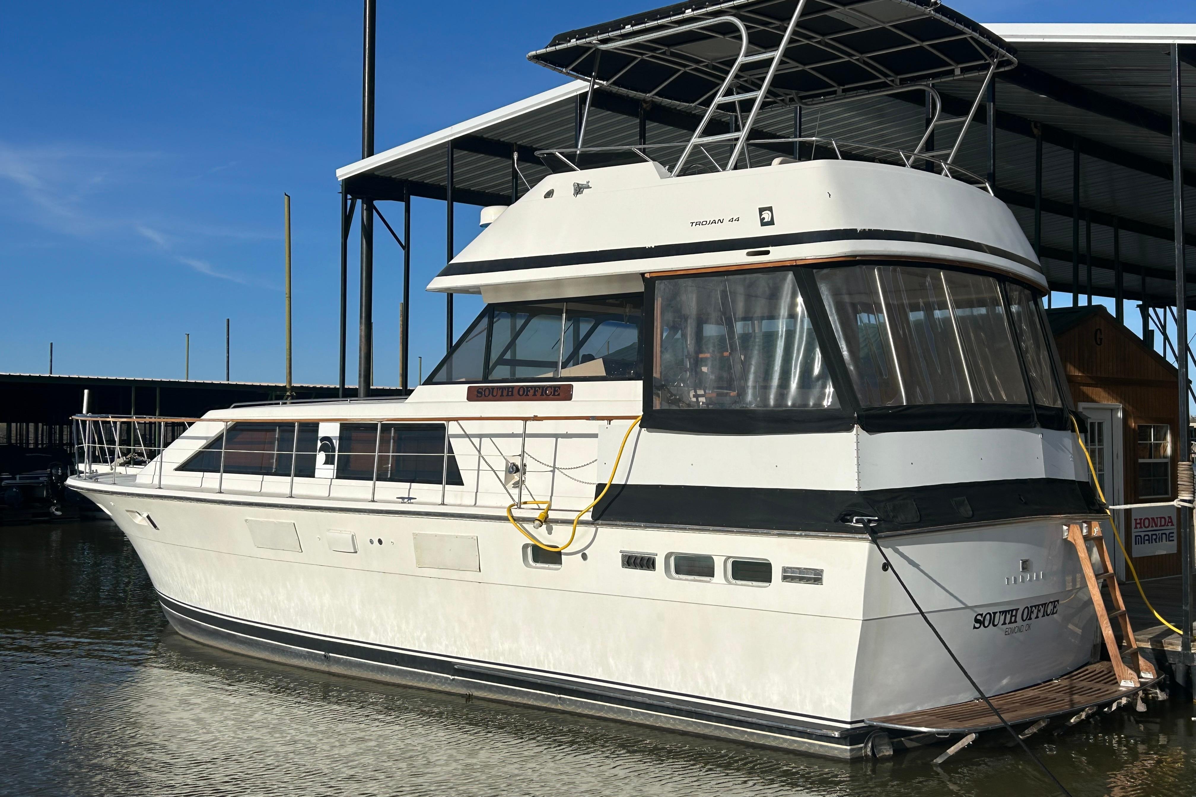 1980 Trojan F44 yacht docked at marina, featuring sleek design and spacious cabin.