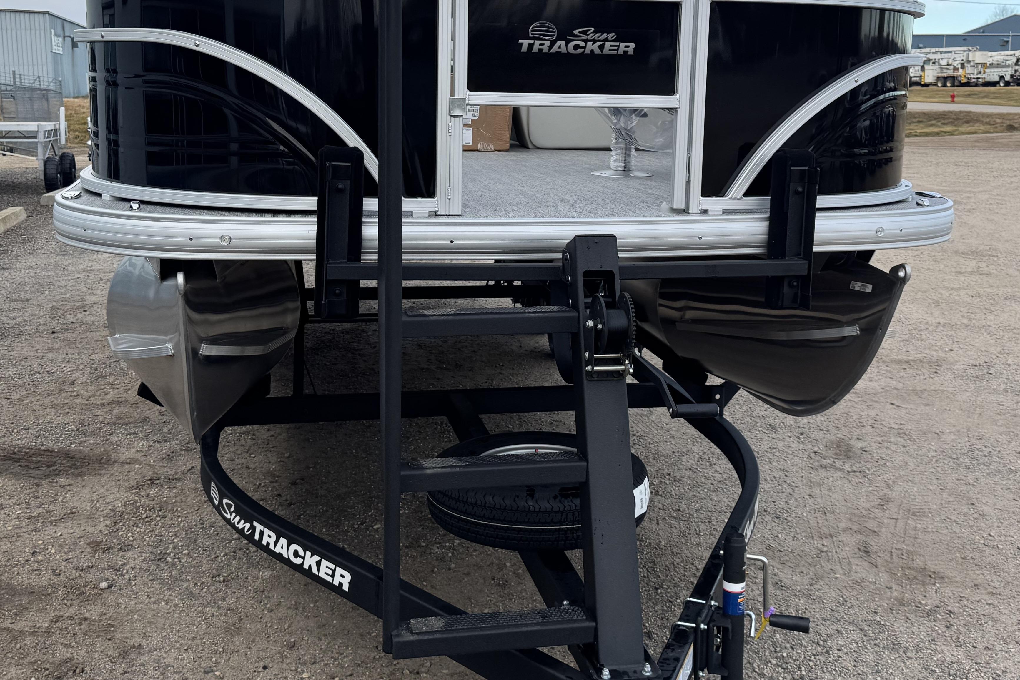 2026 Sun Tracker Fishin' Barge 22 DLX pontoon boat on trailer, front view.