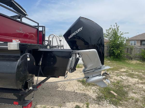 2023 Regency 250DL3 boat with Mercury outboard motor, parked outdoors.