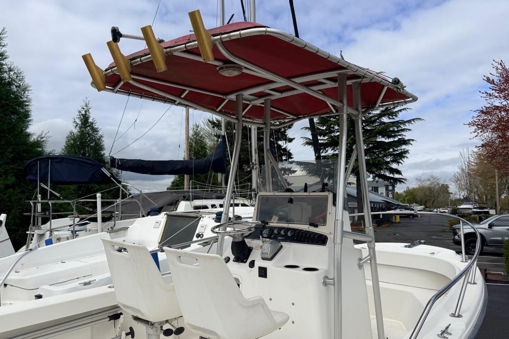 1999 Boston Whaler Outrage 18 boat with red canopy and dual white seats.
