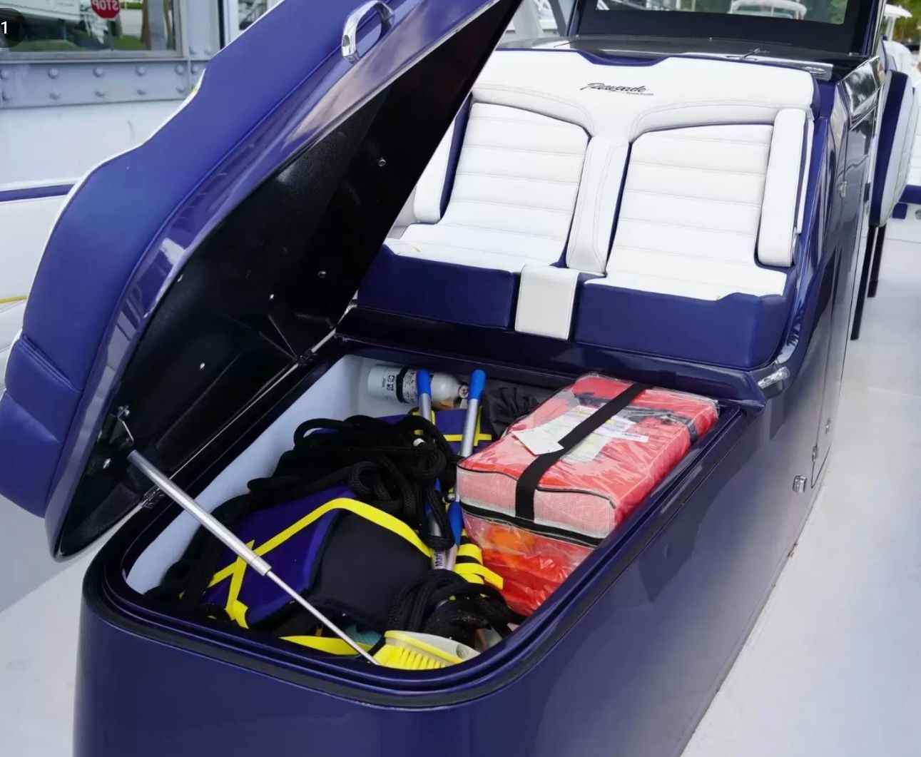 An open storage compartment on a boat reveals life jackets and ropes.