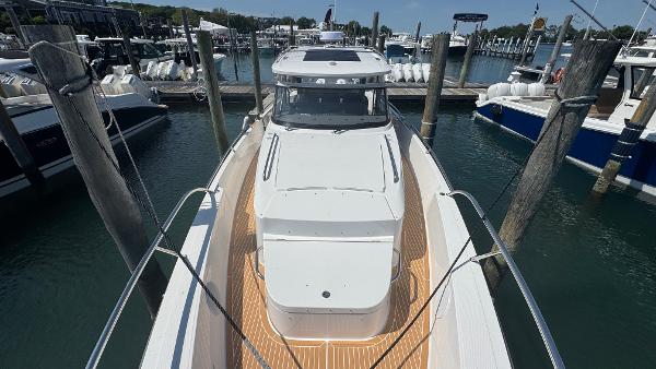 2025 Nimbus T11 boat docked at marina, showcasing sleek design and spacious deck.