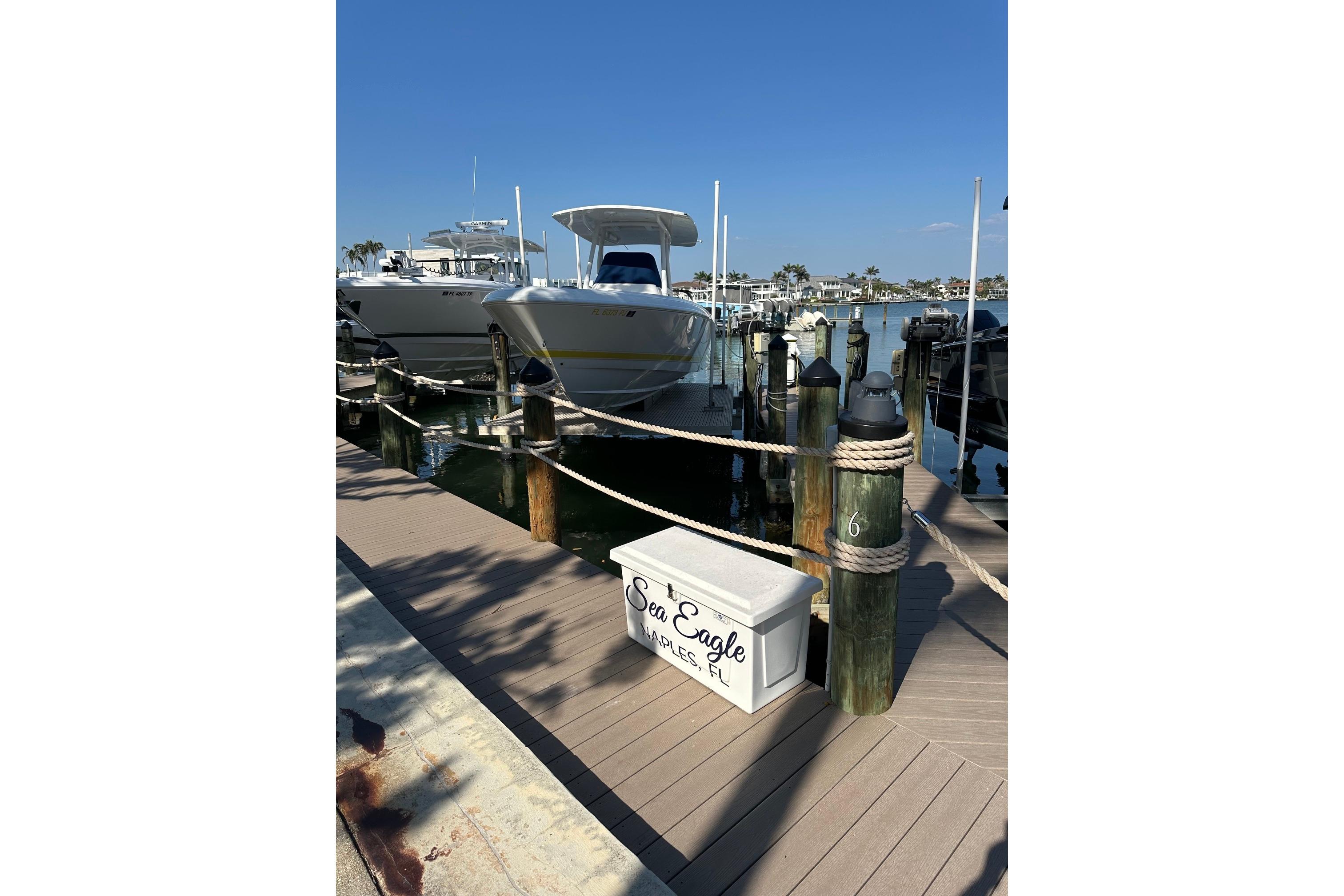 2013 Intrepid 300 Center Console boat docked at marina under clear blue sky.