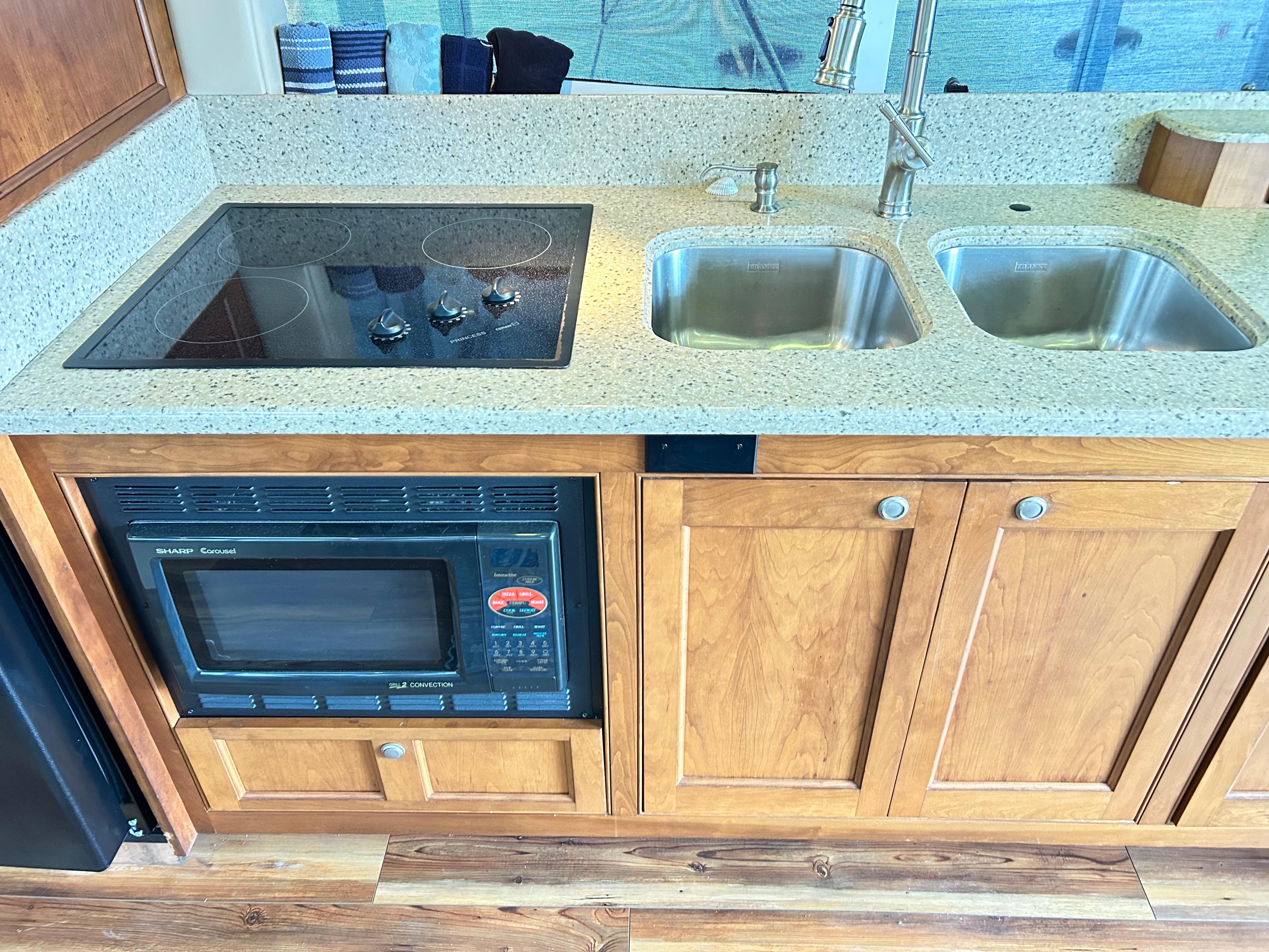 2004 Cruisers Yachts 5000 Sedan Sport kitchen with stove, microwave, and double sink.