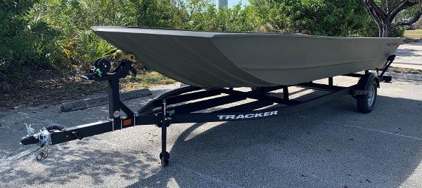 2025 Tracker GRIZZLY 2072 Utility boat on trailer, parked outdoors.