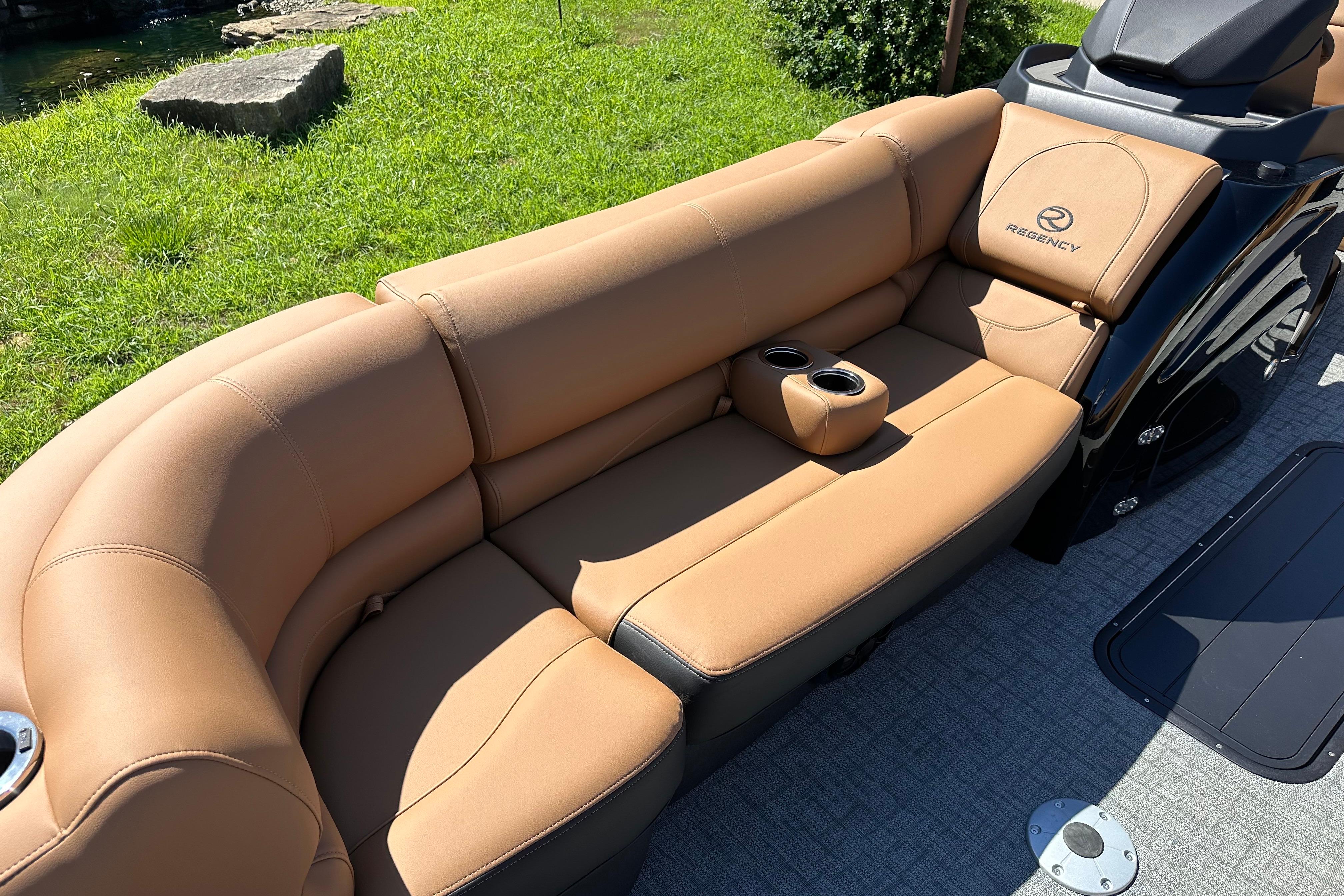 Luxurious tan seating on 2026 Regency 230 DL boat, featuring cup holders and sleek design.