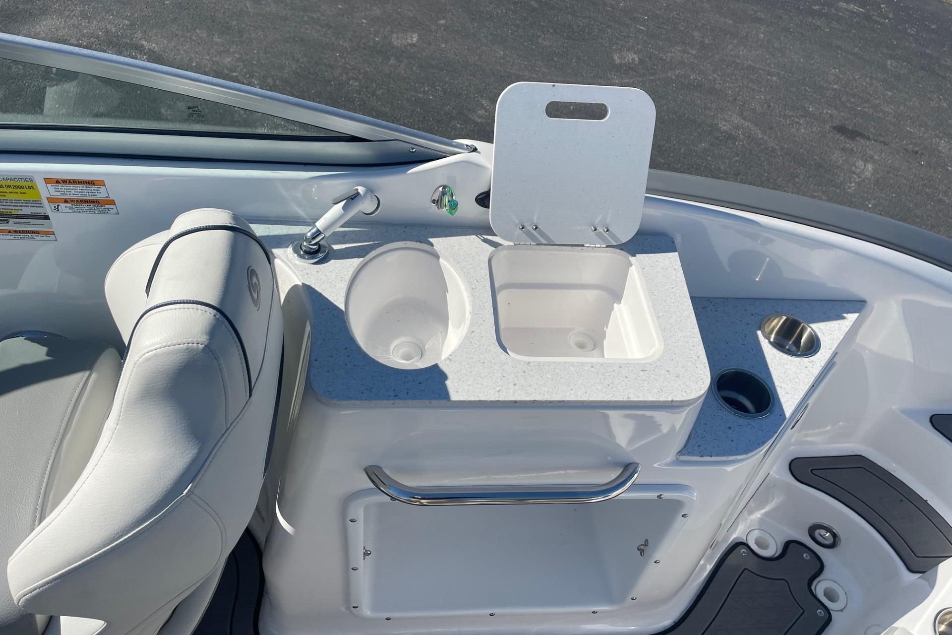 2023 Hurricane SunDeck 2400 OB boat interior with sink and seating area.