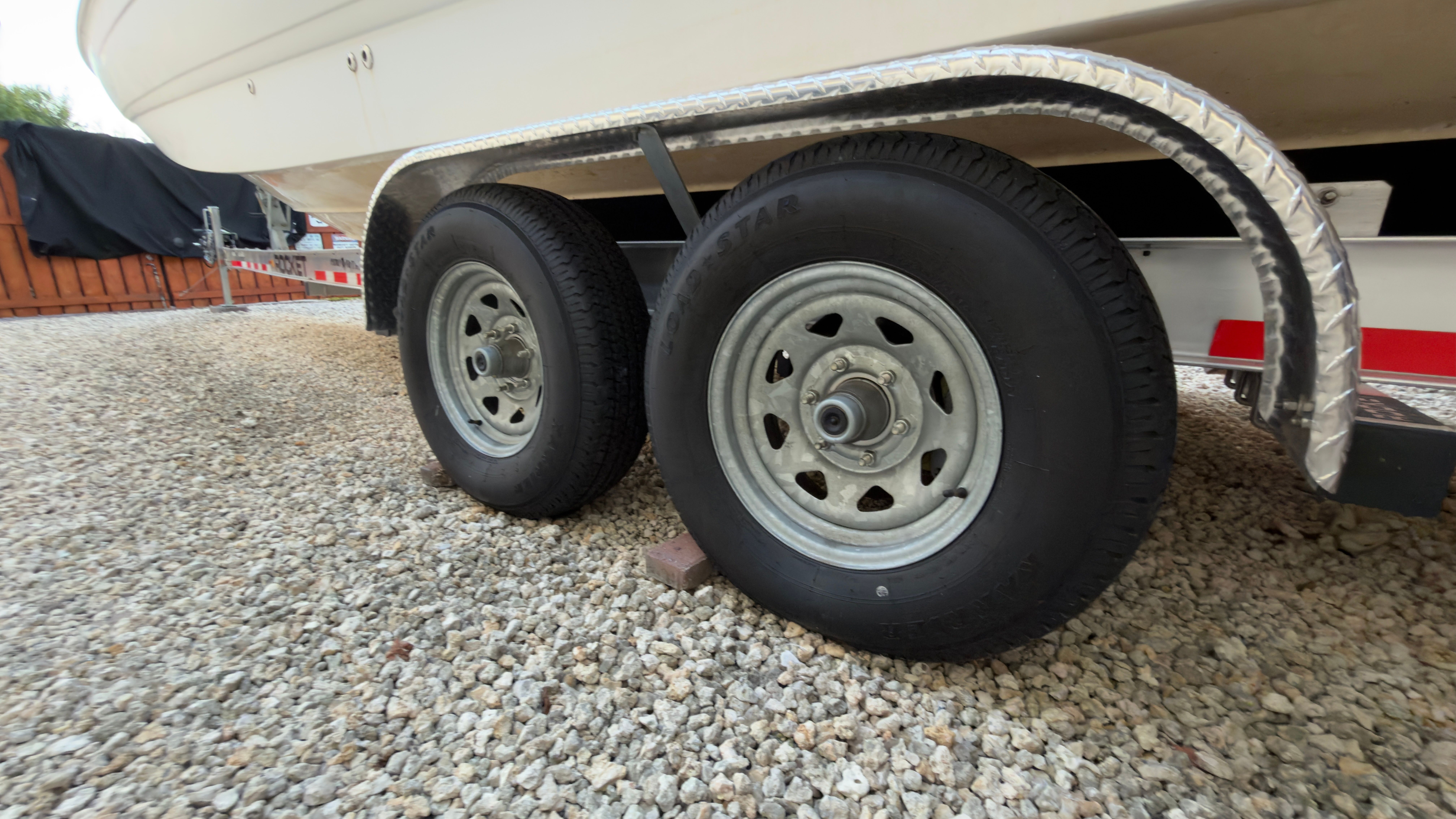 2003 Chaparral 263 Sunesta Deckboat on trailer, close-up of wheels.