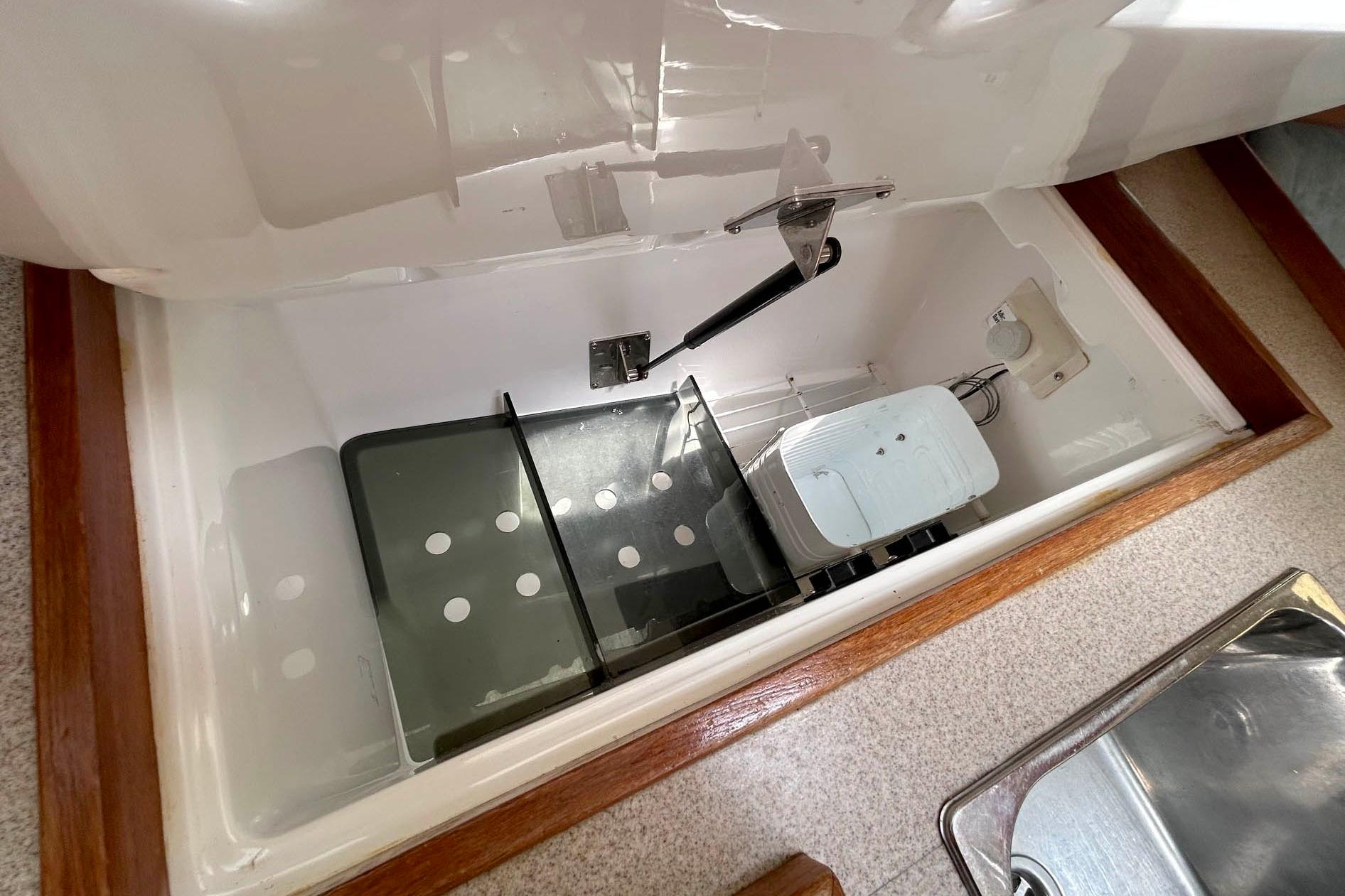 Interior view of a 1998 Hunter 340 sailboat's storage compartment with wooden trim.