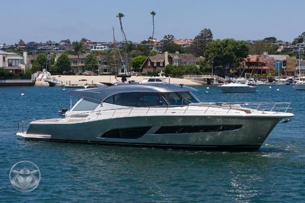 2025 Riviera 645 SUV luxury yacht cruising in a scenic harbor.