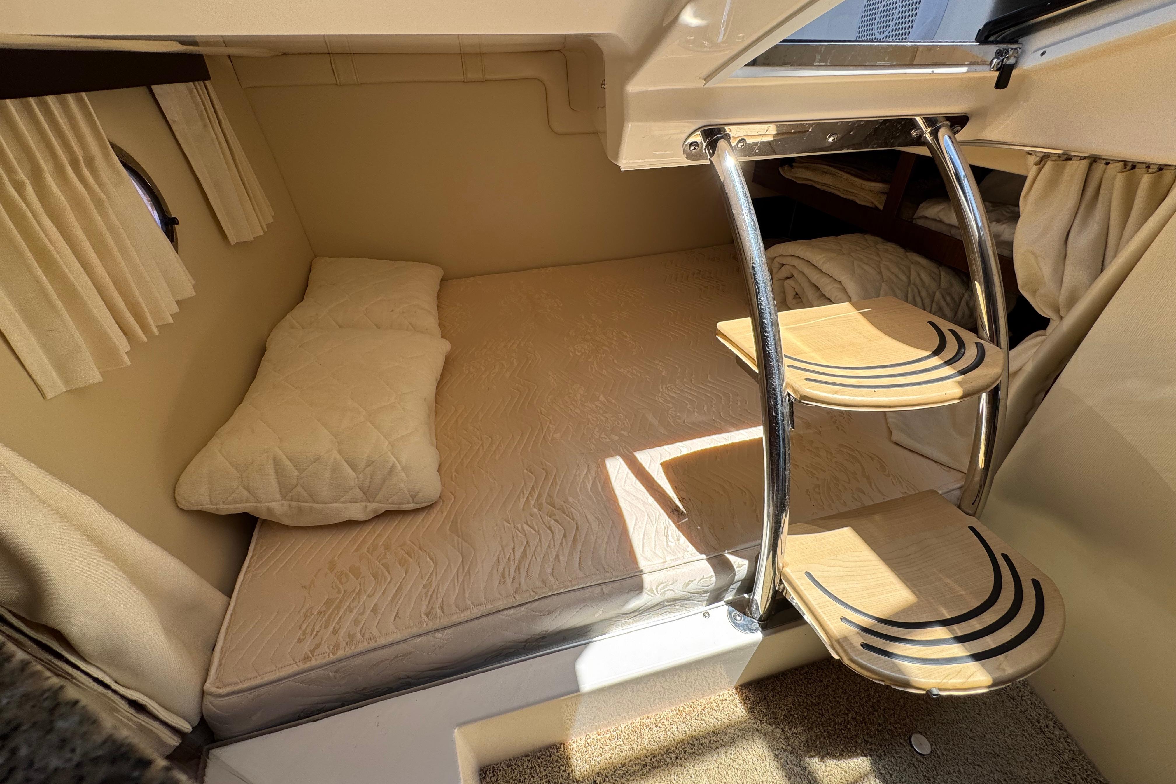 2013 Regal 28 Express cabin interior with cozy bed and wooden steps.
