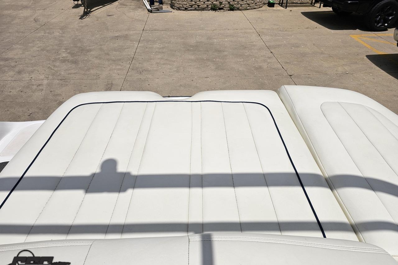 2010 Cobalt 232 WSS boat with white cushioned seating, outdoor setting.