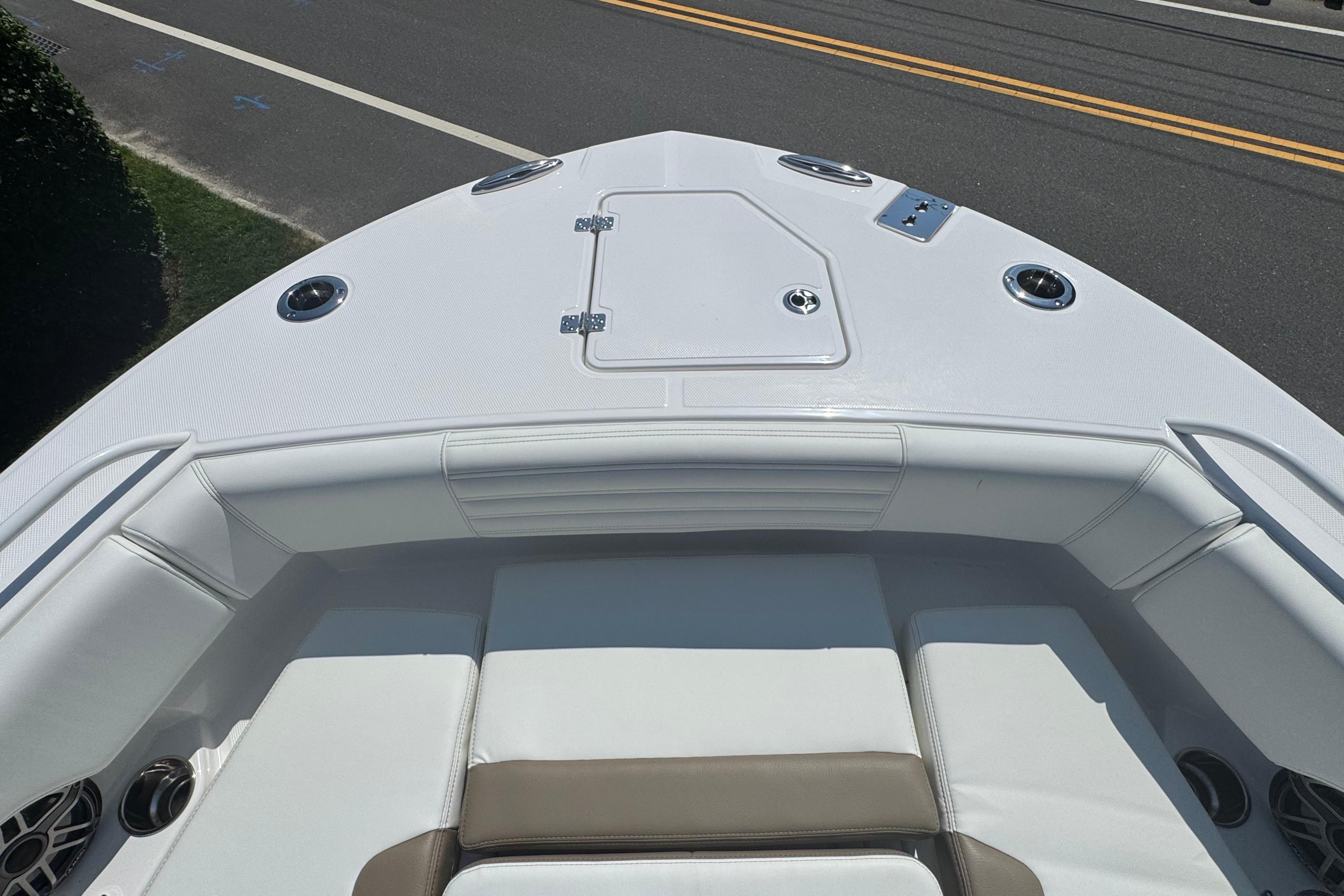 Bow view of 2026 Edgewater 250CC boat with white seating and storage hatch.