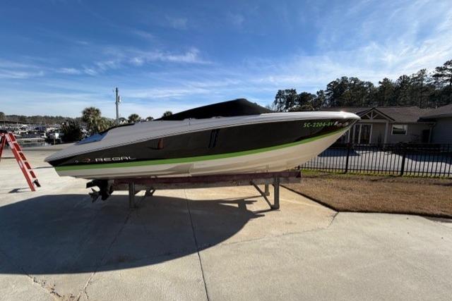 2005 Regal 2200 Bowrider boat on a stand, outdoors under clear blue sky.
