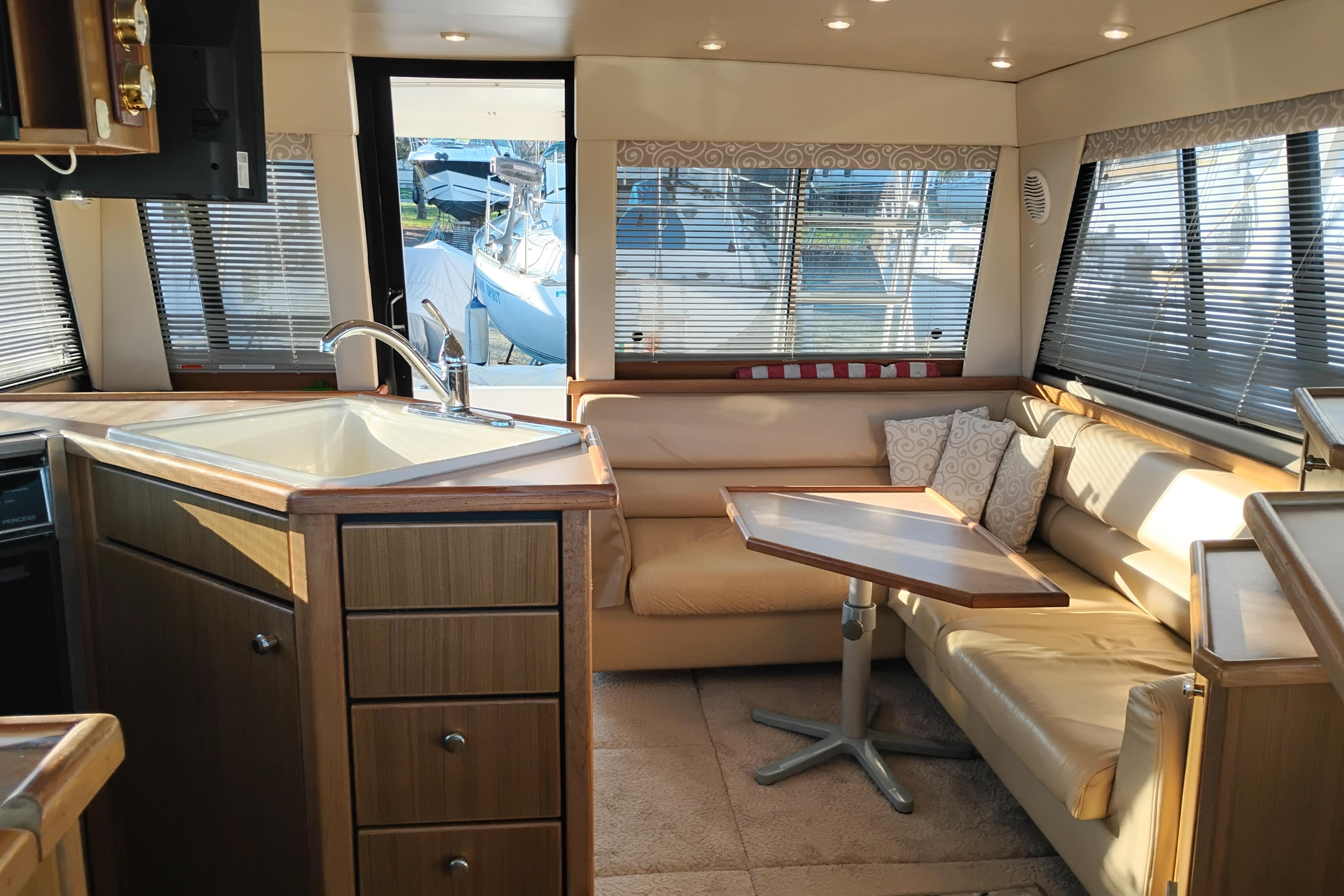 Interior of 2000 Bayliner 3988 Command Bridge Motoryacht with cozy seating and kitchen area.