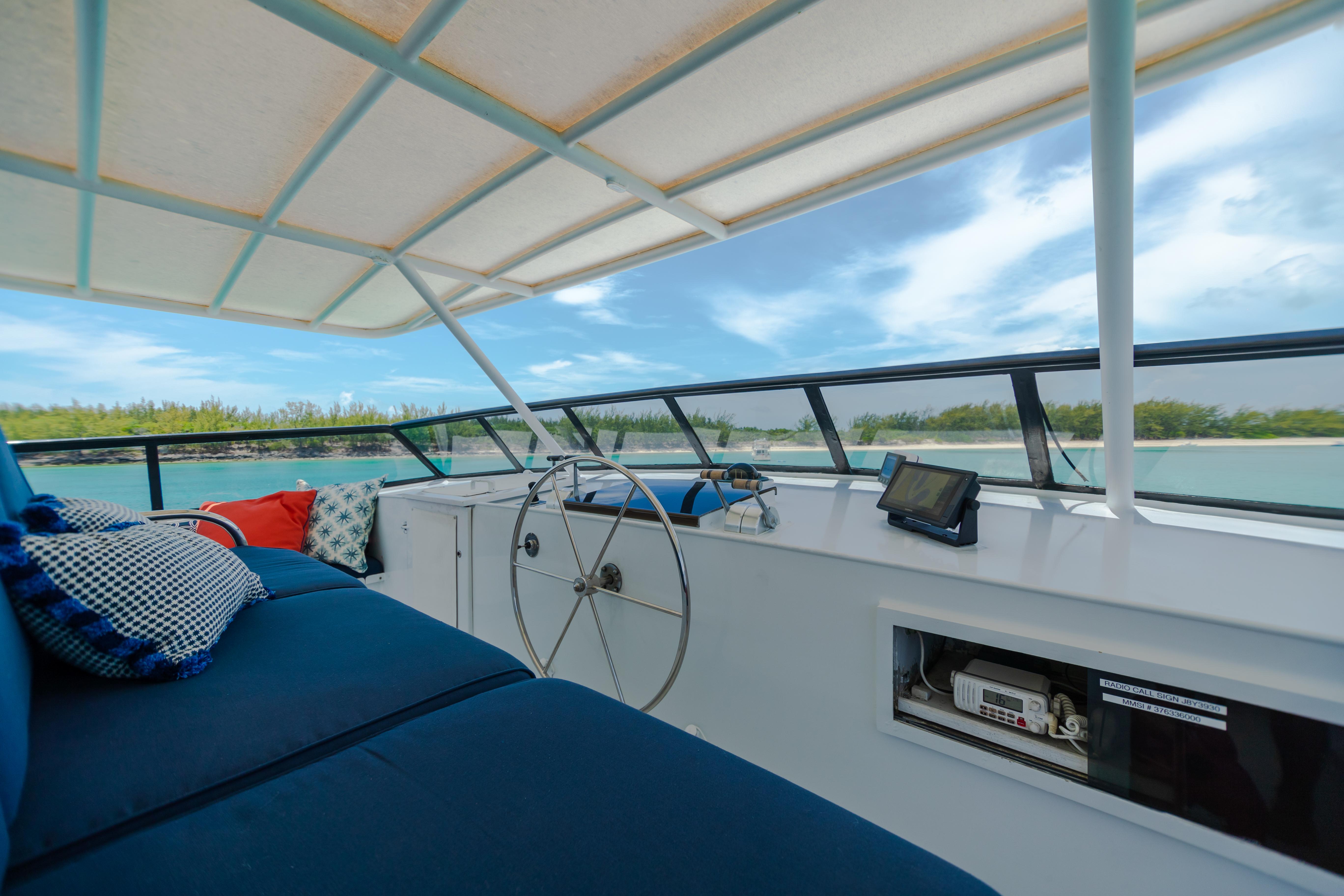 1991 Broward Motor Yacht helm with blue seating and scenic ocean view.