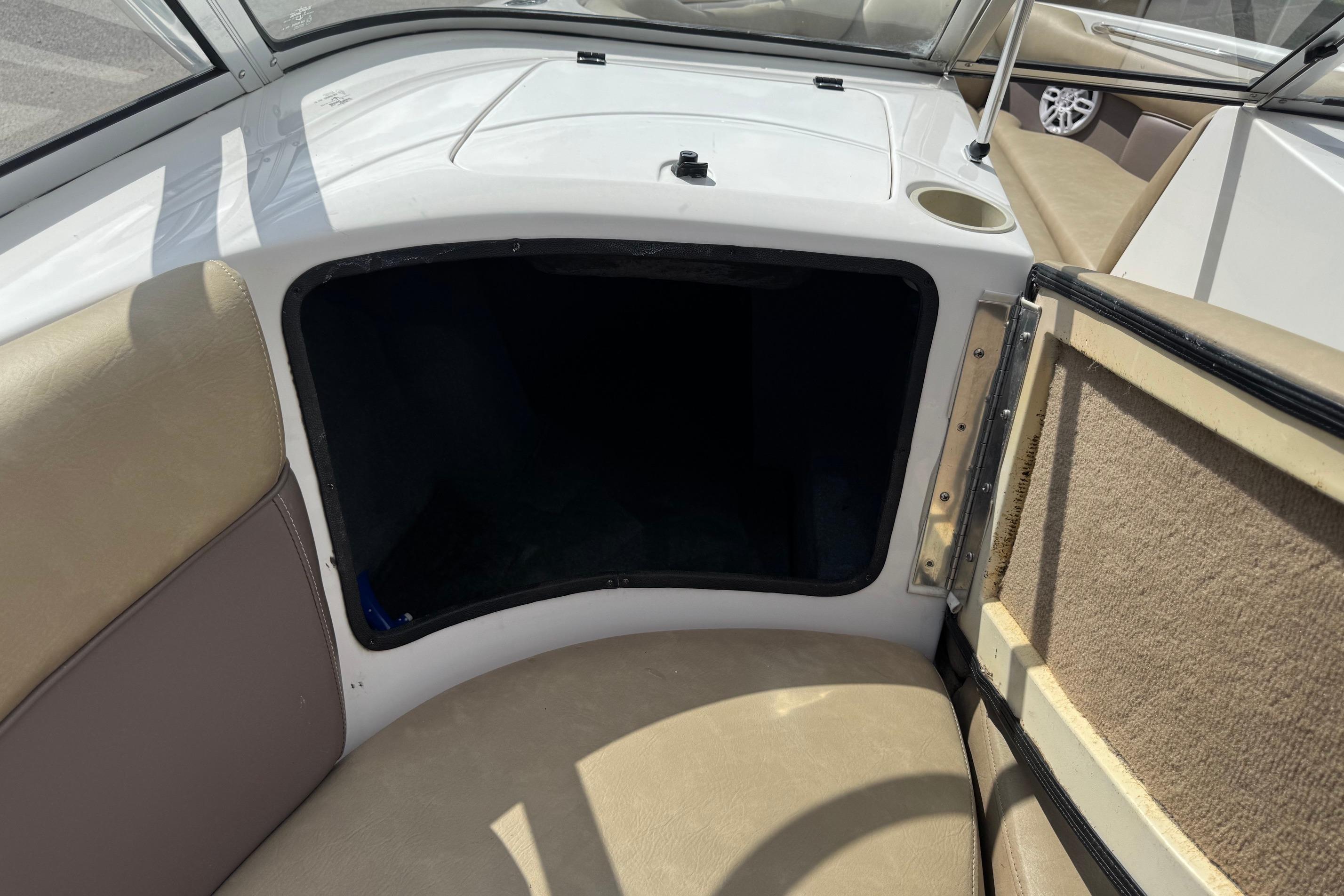 Interior of a 2002 Supra Launch 22 SSV boat, featuring seating and storage compartment.